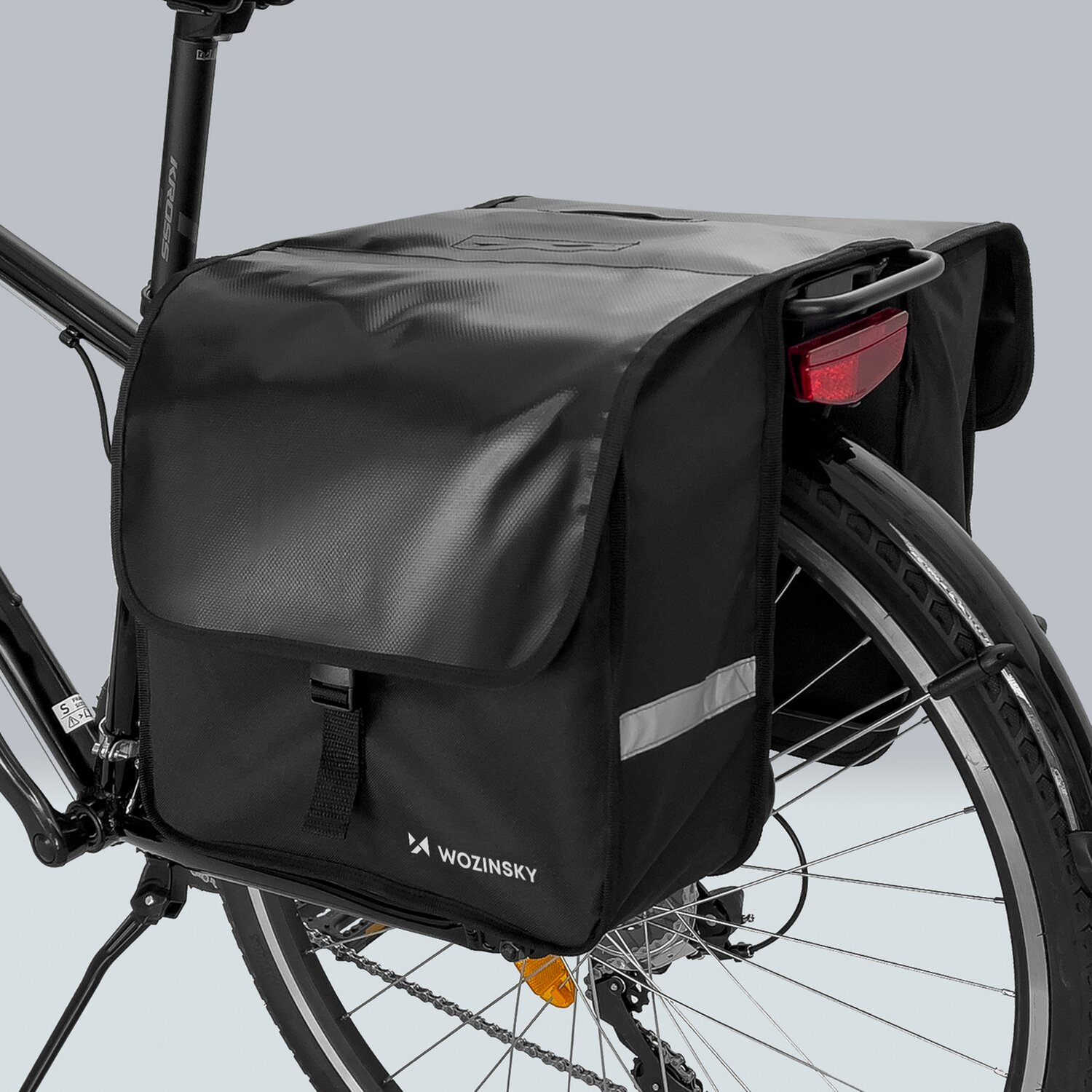 Schwarze Fahrradtaschen an einem Fahrrad, mit rotem Licht und Reflektor. Wozinsky Logo vorhanden.