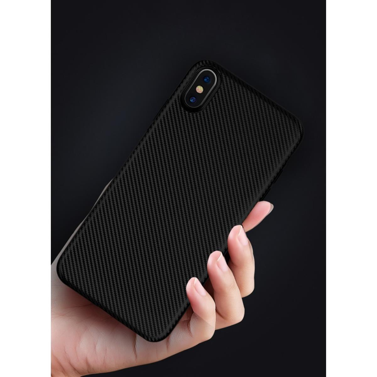 Hand hält ein schwarzes Telefon. Telefon hat eine Kohlefaserkonsistenz. Der Hintergrund ist verschwommen schwarz.
