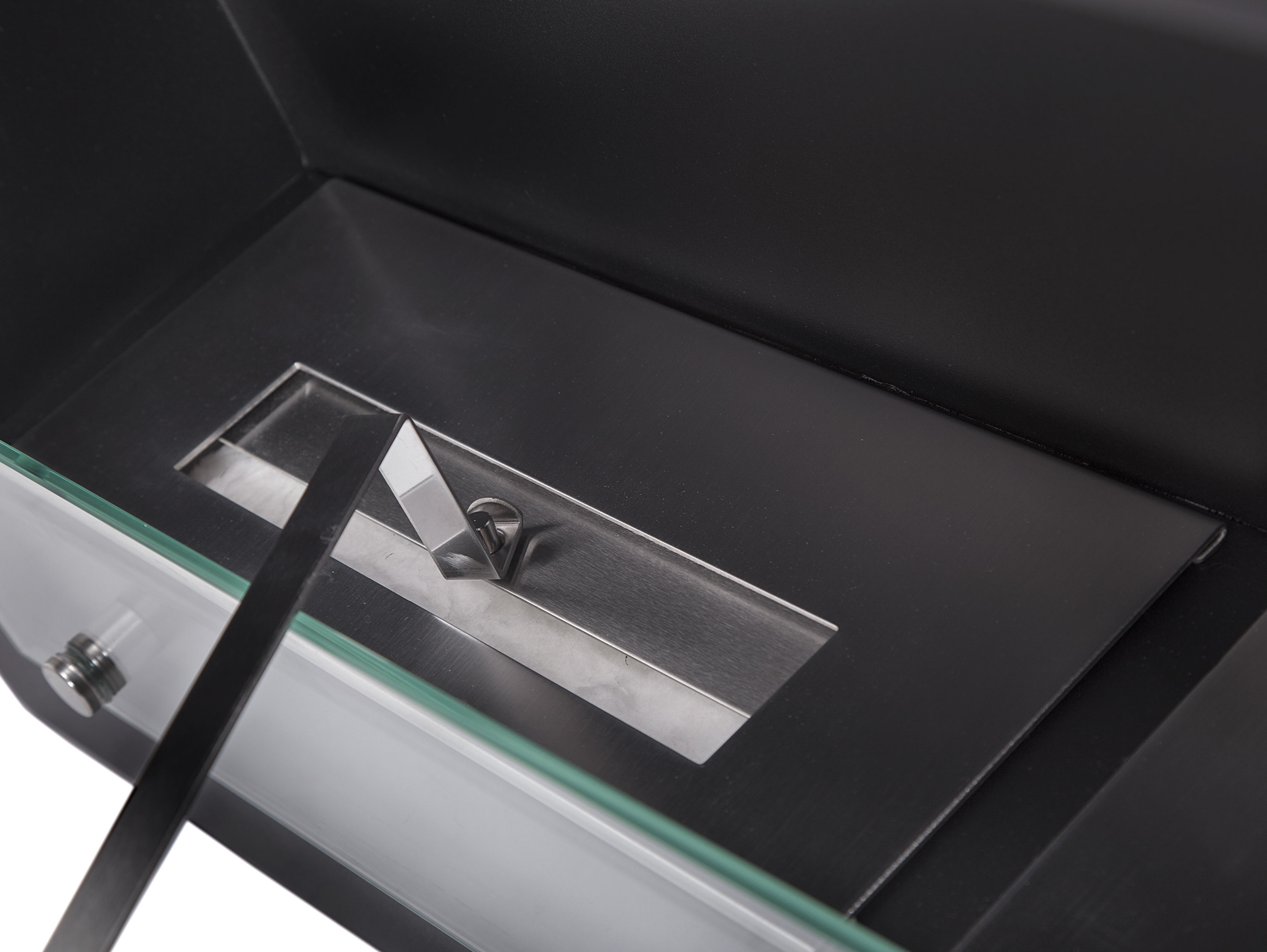 Nahaufnahme eines Kamins. Das schwarze Innere hat eine Metallplatte mit einer kleinen Öffnung.