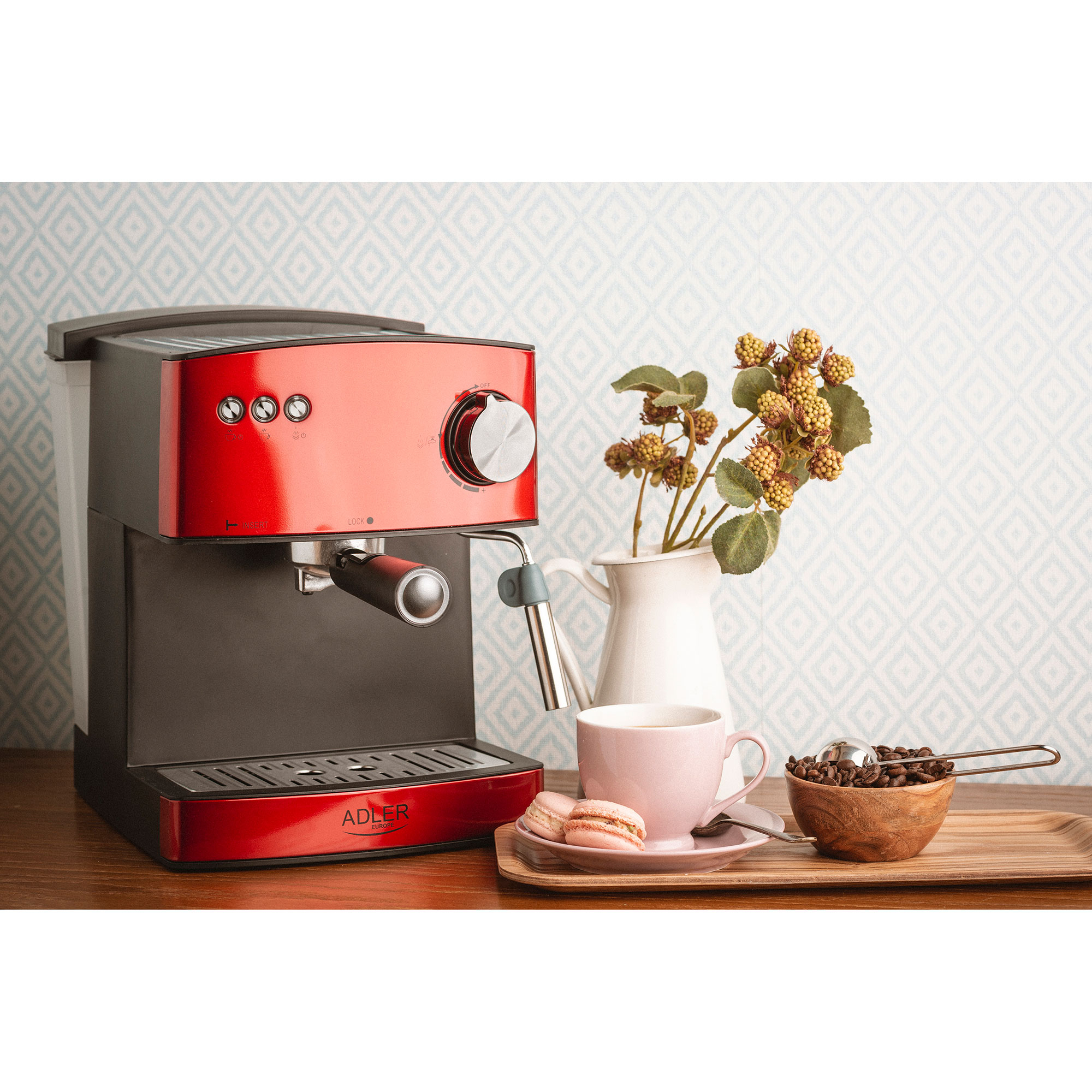 Rote und schwarze Espressomaschine mit Zubehör auf Holztablett. Beinhaltet Kaffeetasse und Makronen.