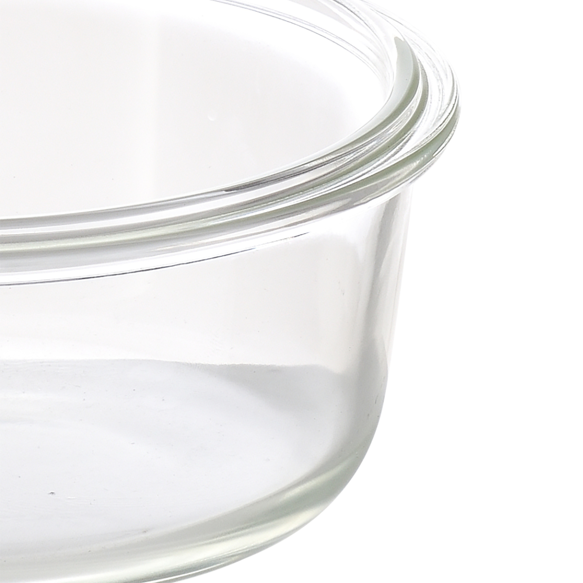 Primer plano del borde curvado de un recipiente de vidrio transparente. Fondo blanco.