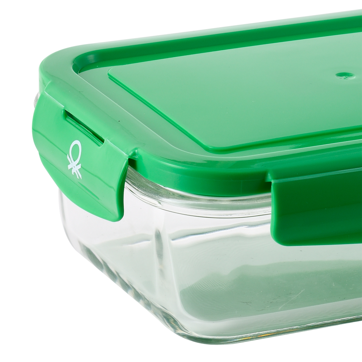 Un recipiente para alimentos verde y transparente. La tapa es verde y está cerrada. El recipiente es de vidrio.