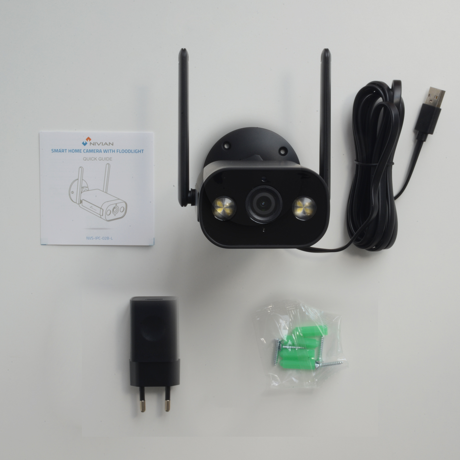 Cámara de seguridad con accesorios, incluido un adaptador de corriente y una guía rápida.