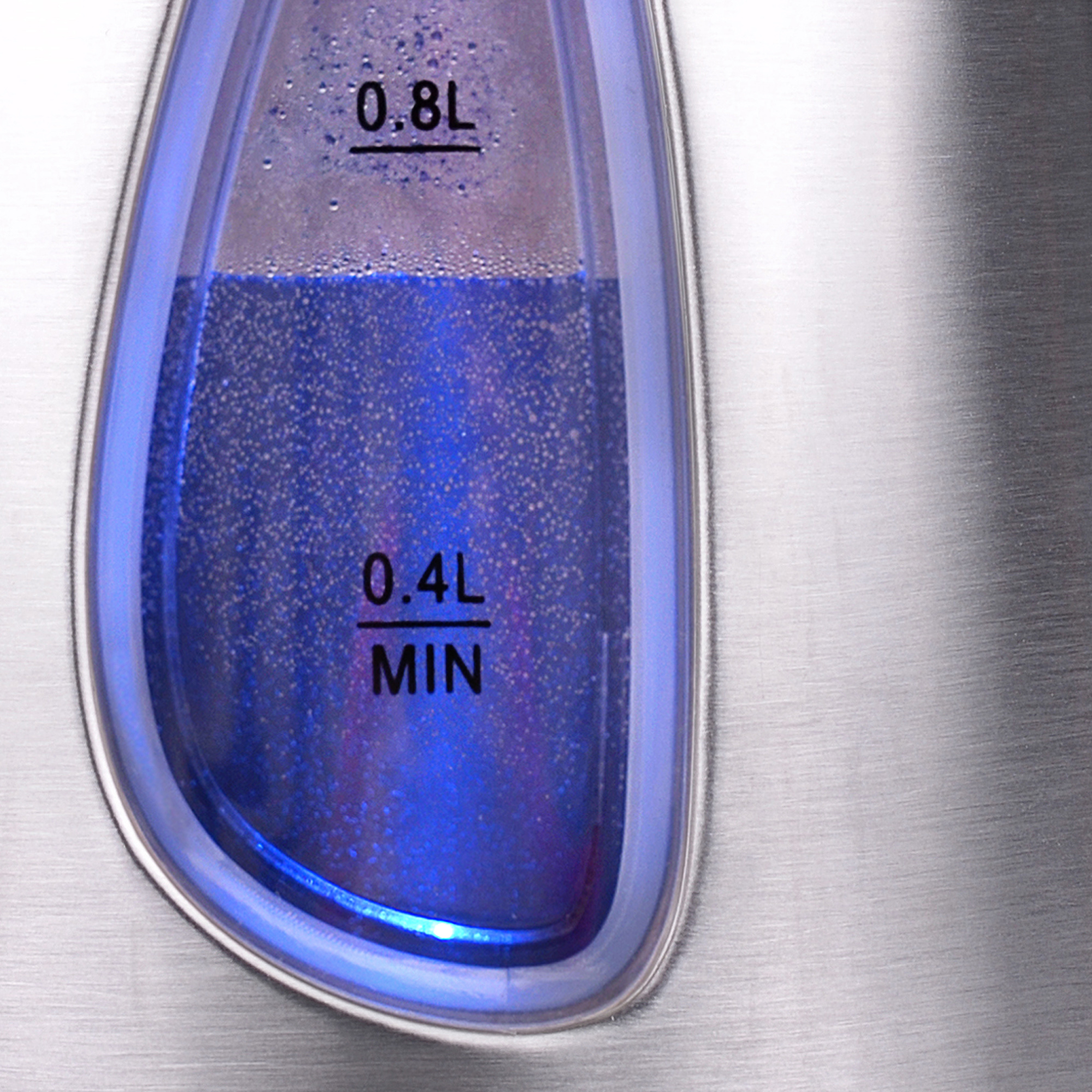 Zbliżenie wskaźnika poziomu wody w czajniku wypełnionego niebiesko oświetloną wodą.