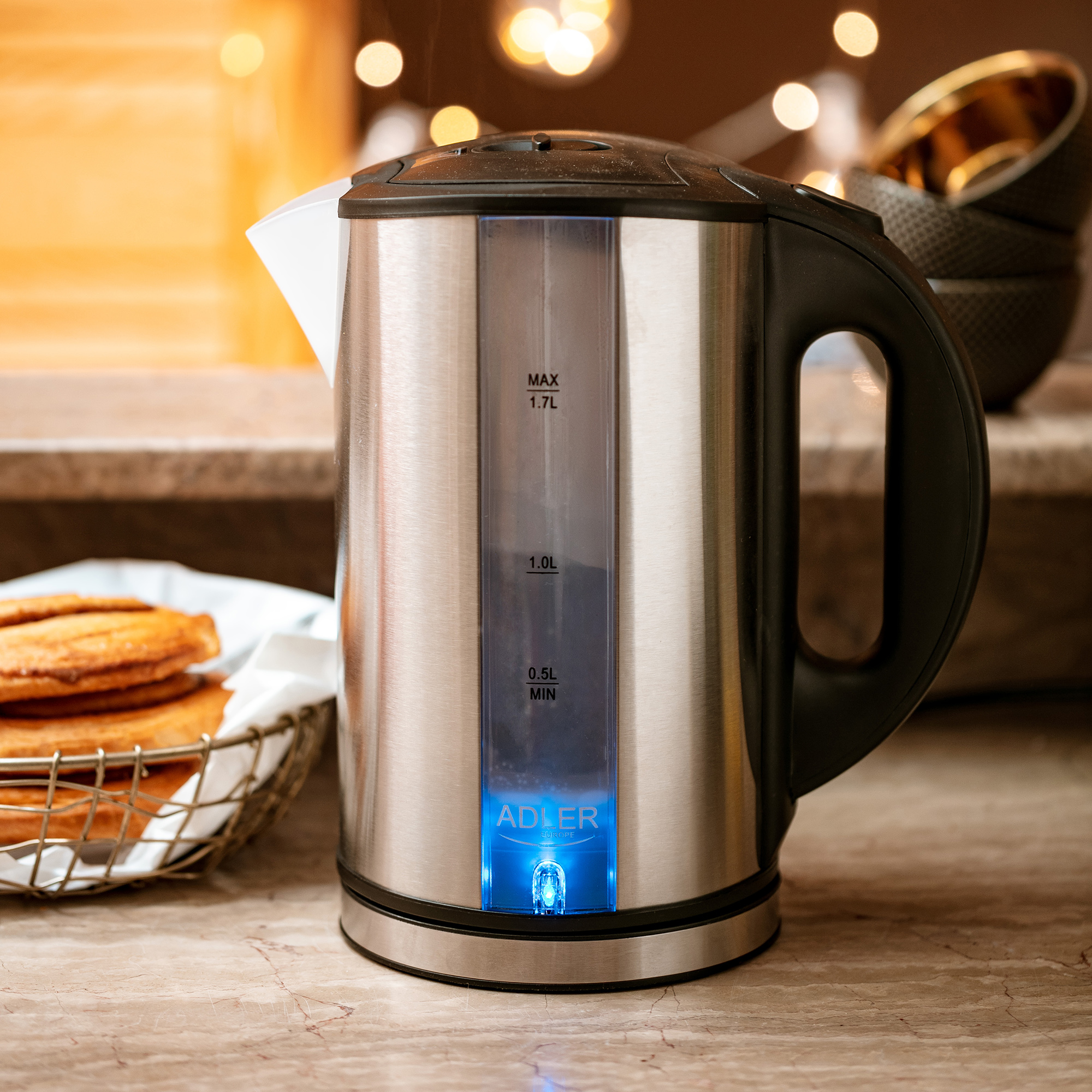 Czajnik elektryczny ze stali nierdzewnej z czarnym uchwytem na blacie.