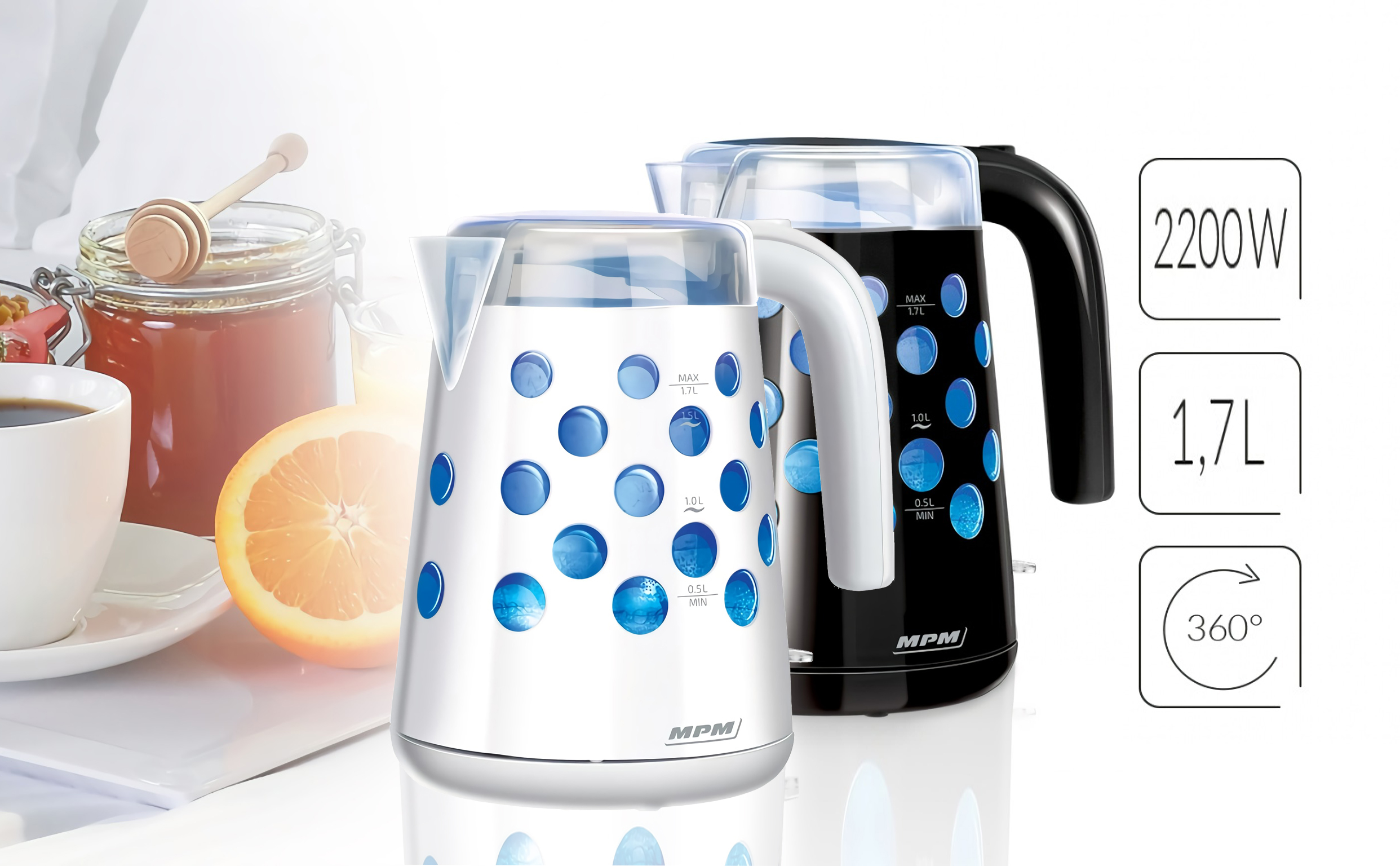 Dwa czajniki elektryczne, jeden biały z niebieskimi kółkami, a drugi czarny. Znajdują się w pobliżu miodu, pomarańczy i kawy.