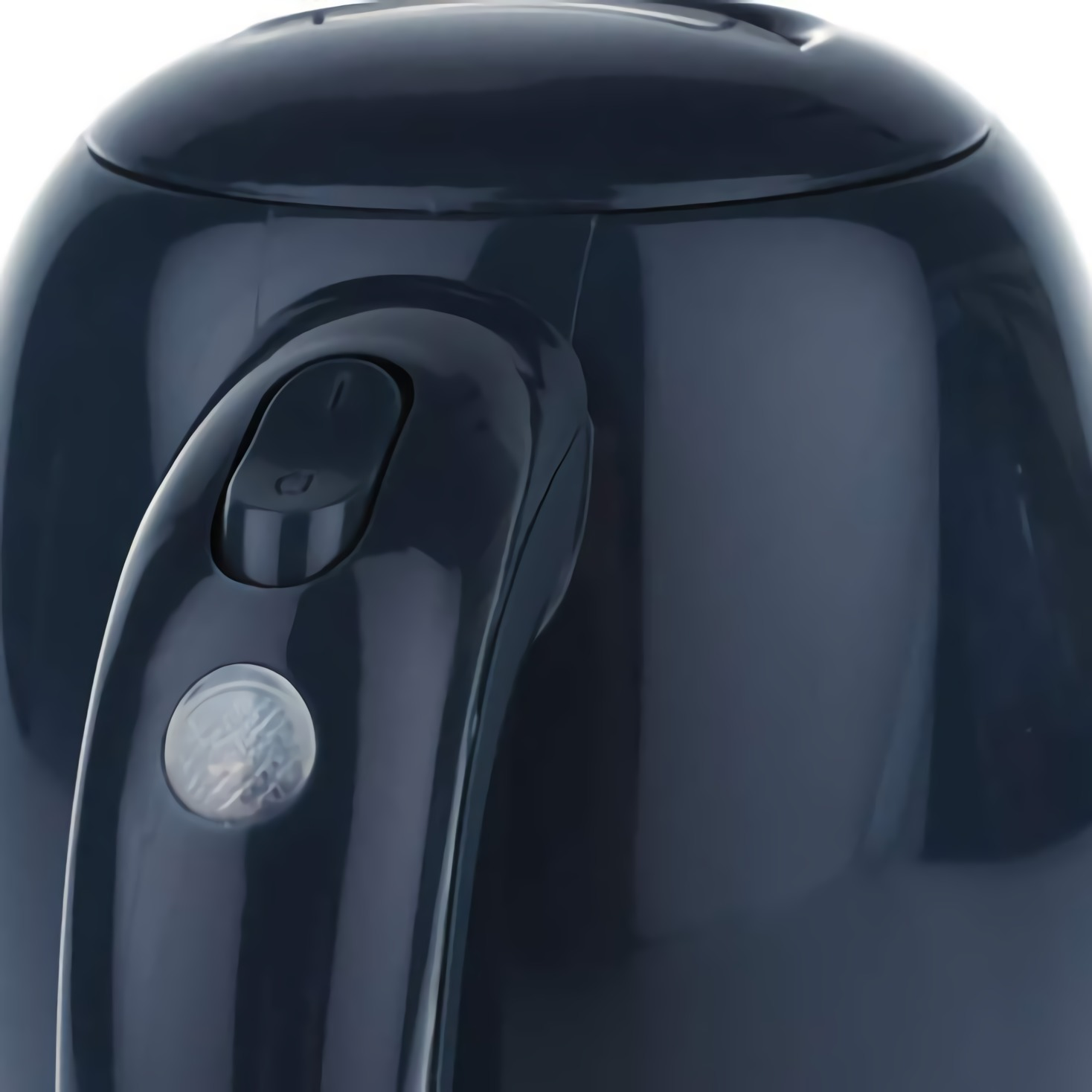 Zbliżenie na granatowy czajnik elektryczny z uchwytem i przyciskami.