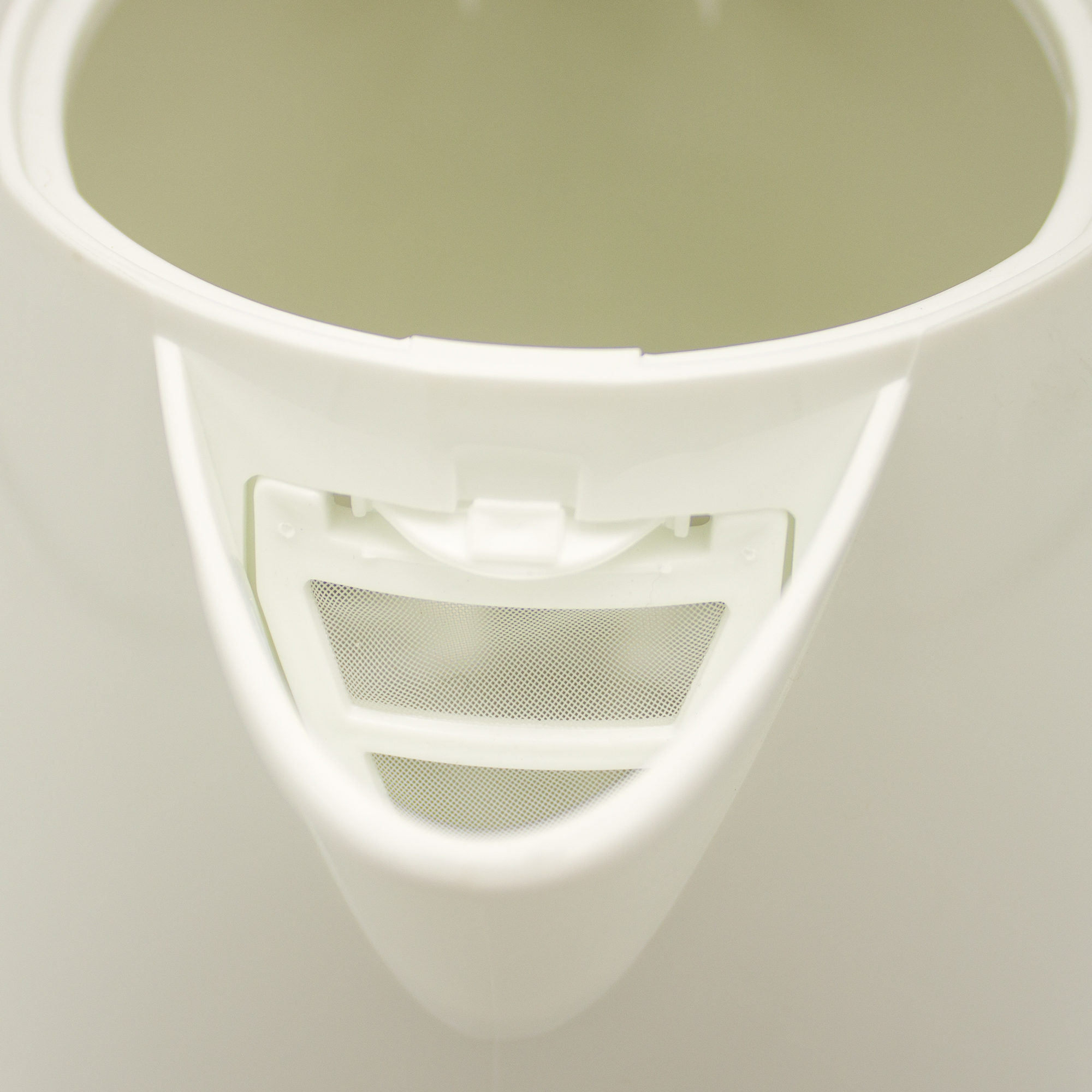 Wnętrze białego czajnika, pokazujące filtr. Białe tło.