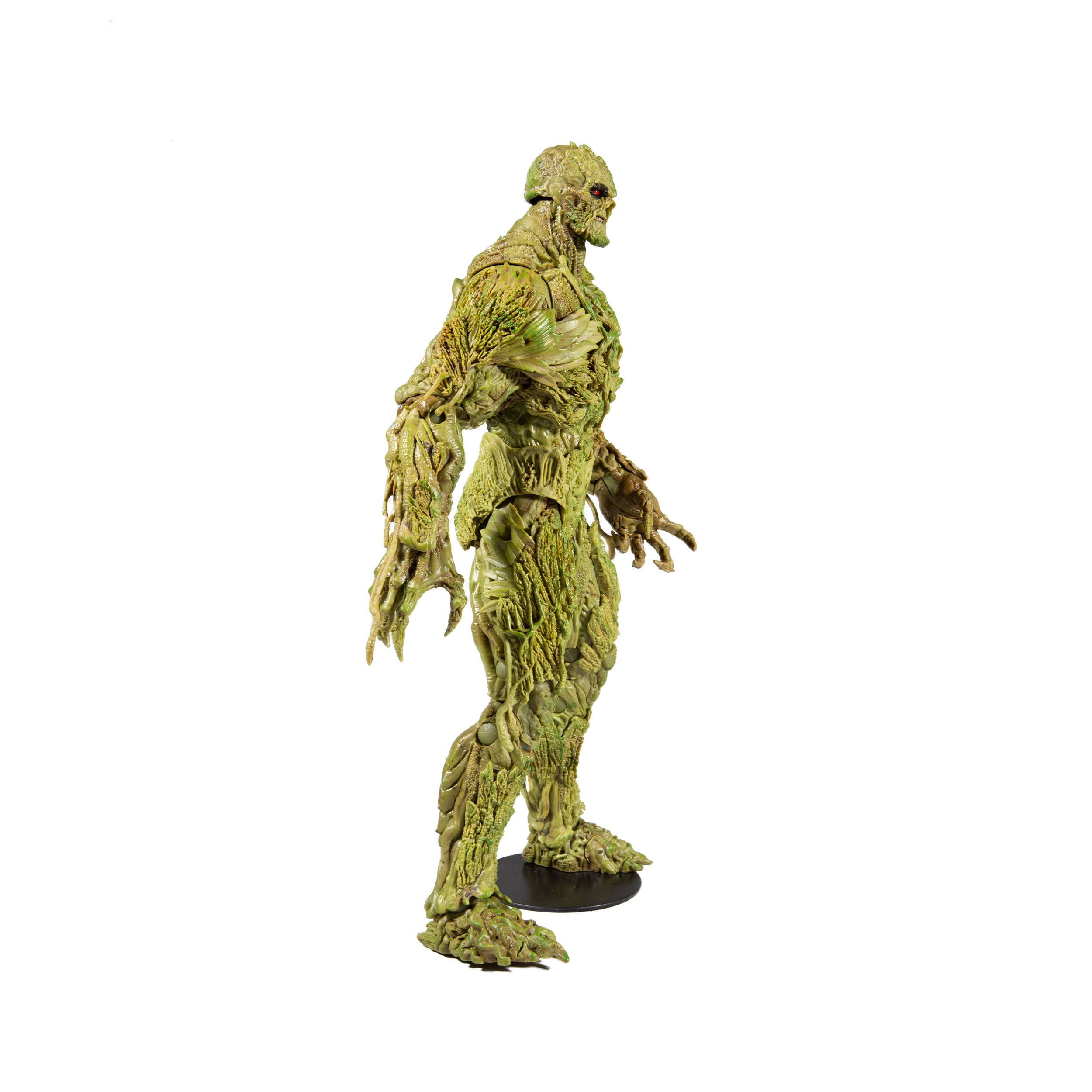 Eine grüne Swamp Thing Figur steht auf einem schwarzen Sockel. Die Figur ist detailliert und hat eine moosige Textur.