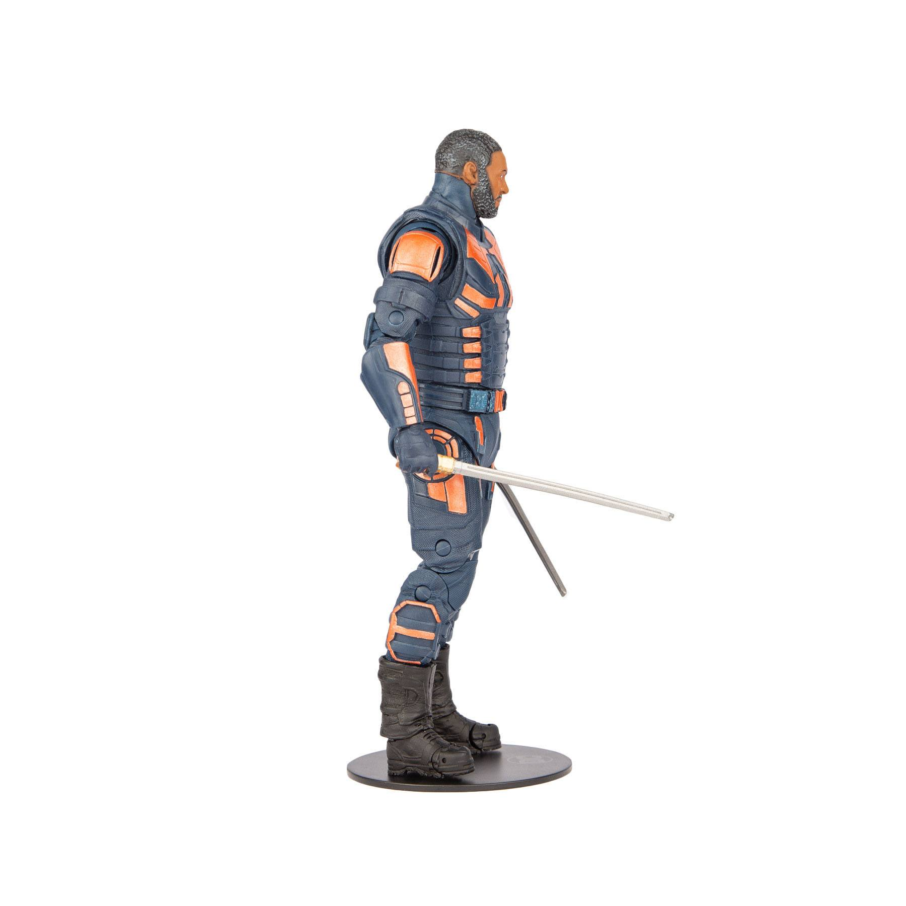 Actionfigur mit blauer und orangefarbener Uniform und 2 Schwertern. Schwarze Basis. Seitenansicht. Weißer Hintergrund.