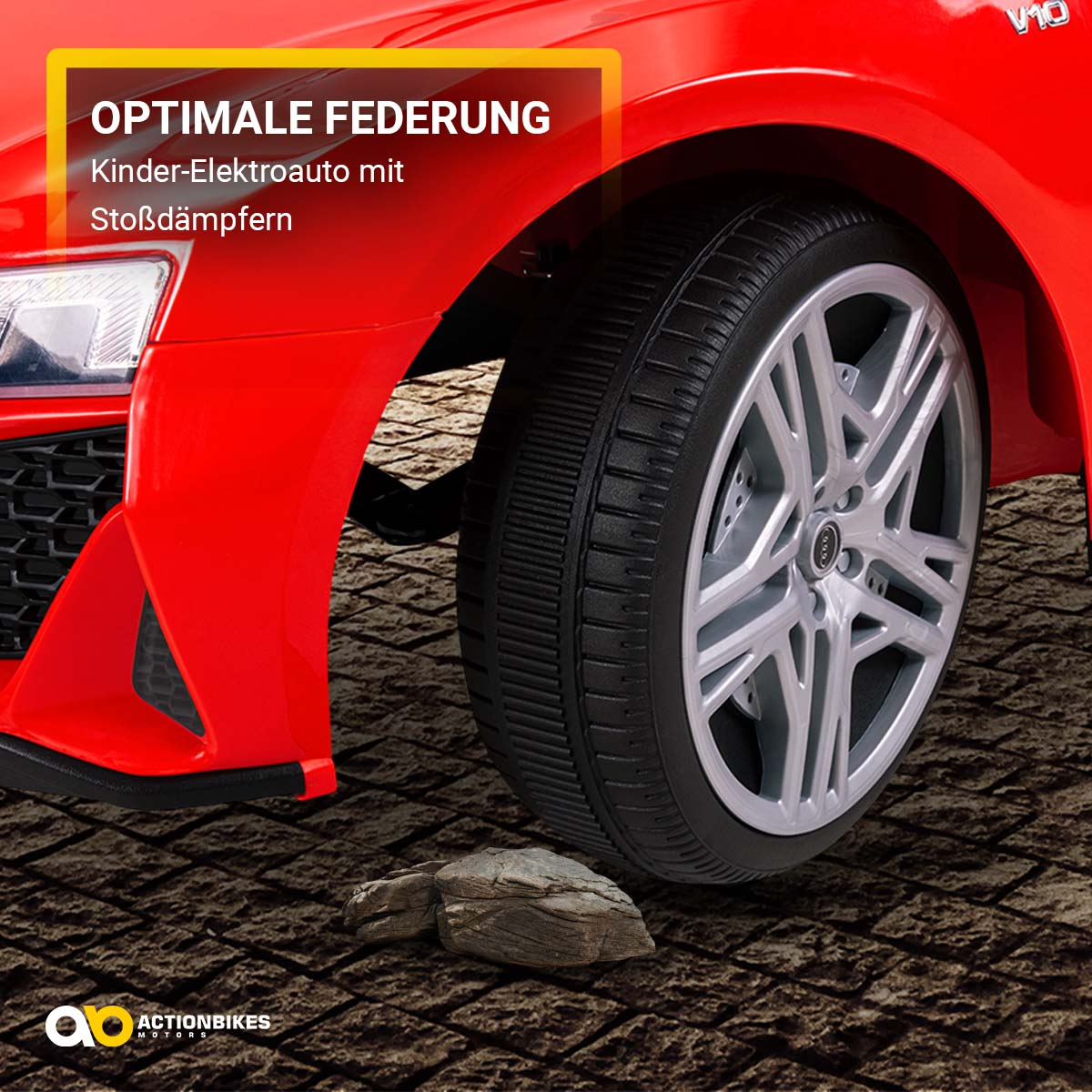 Rotes Spielzeugauto, Nahaufnahme von Rad und Federung. Braune ziegelartige Oberfläche.