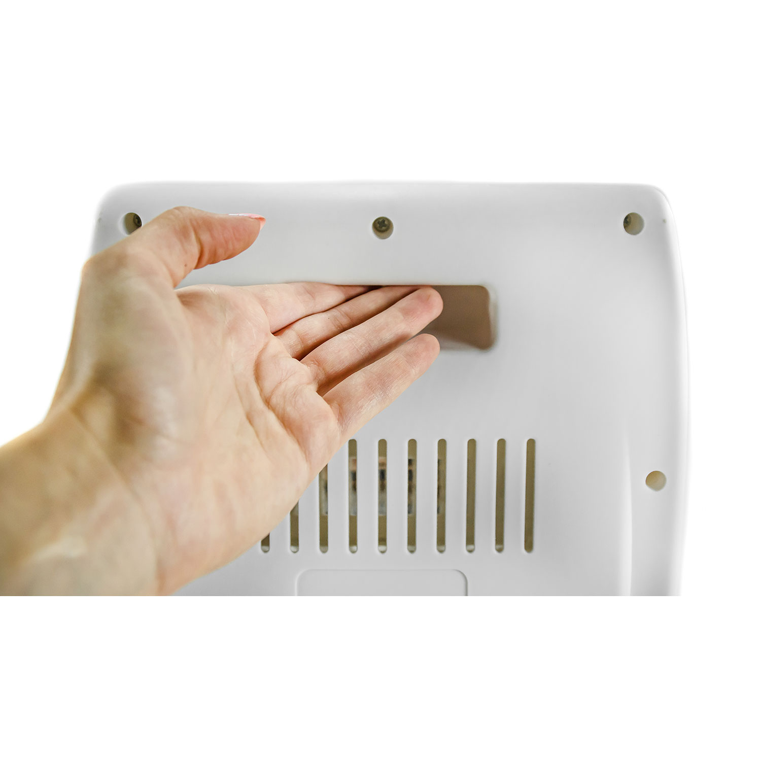 Una mano que se acerca a un objeto blanco con una abertura rectangular y ranuras verticales.
