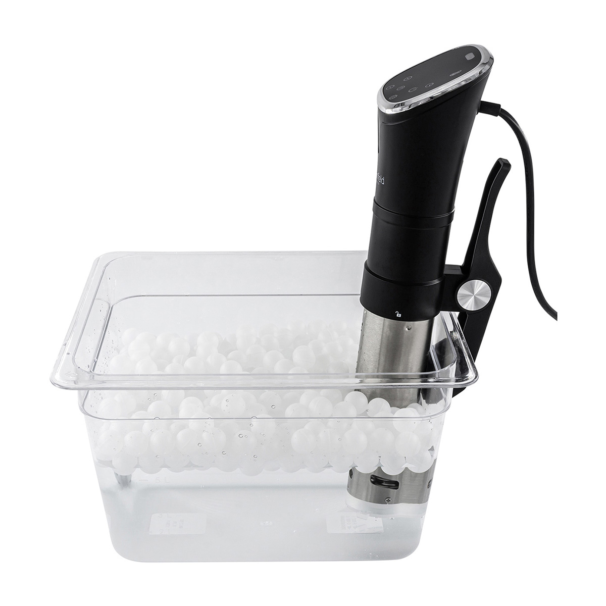 Ein schwarzer Sous-Vide-Immersion-Zirkulator in einem transparenten Kunststoffbehälter mit Wasser und weißen Kugeln.
