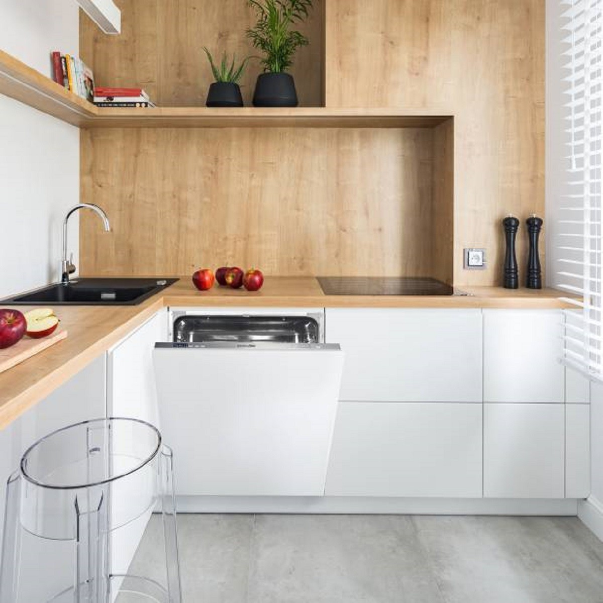 Cocina moderna con gabinetes de madera, encimeras blancas, lavavajillas y algo de decoración.