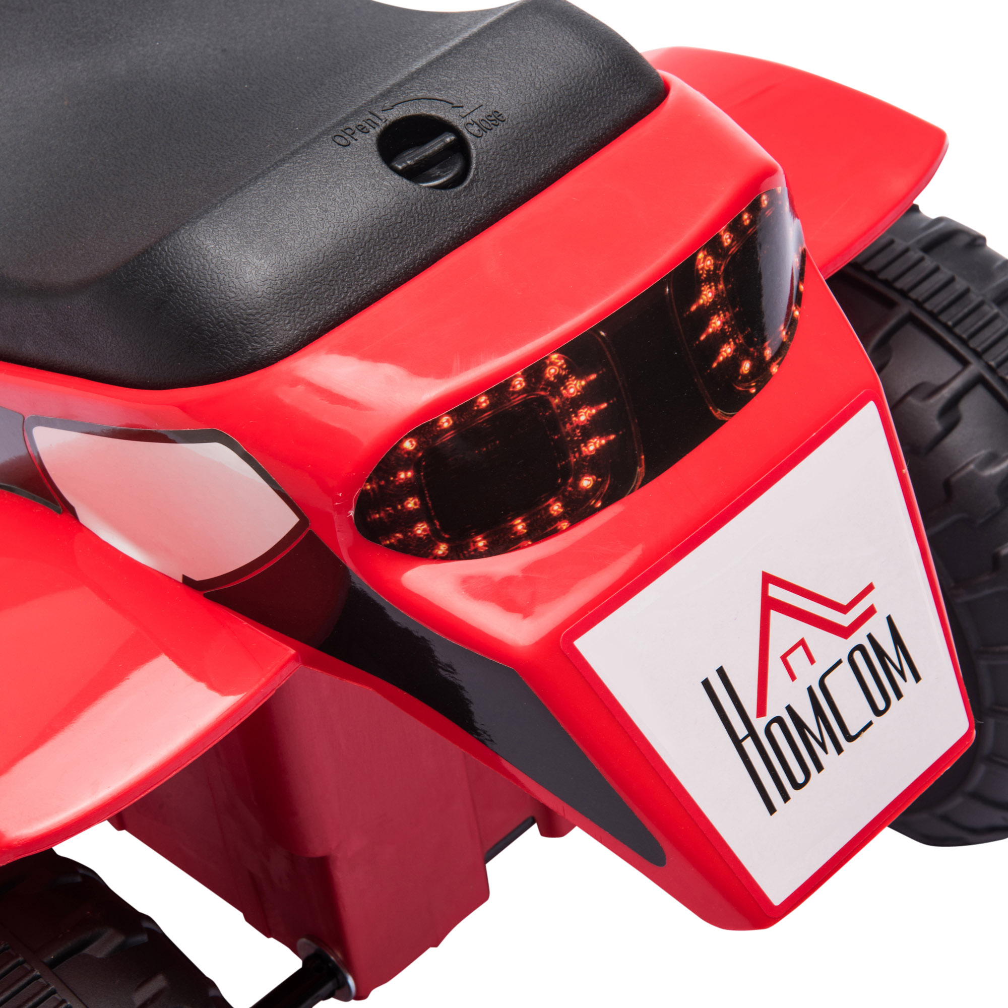 Primo piano della parte posteriore di un'auto giocattolo rossa, che mostra luci e logo Homcom.