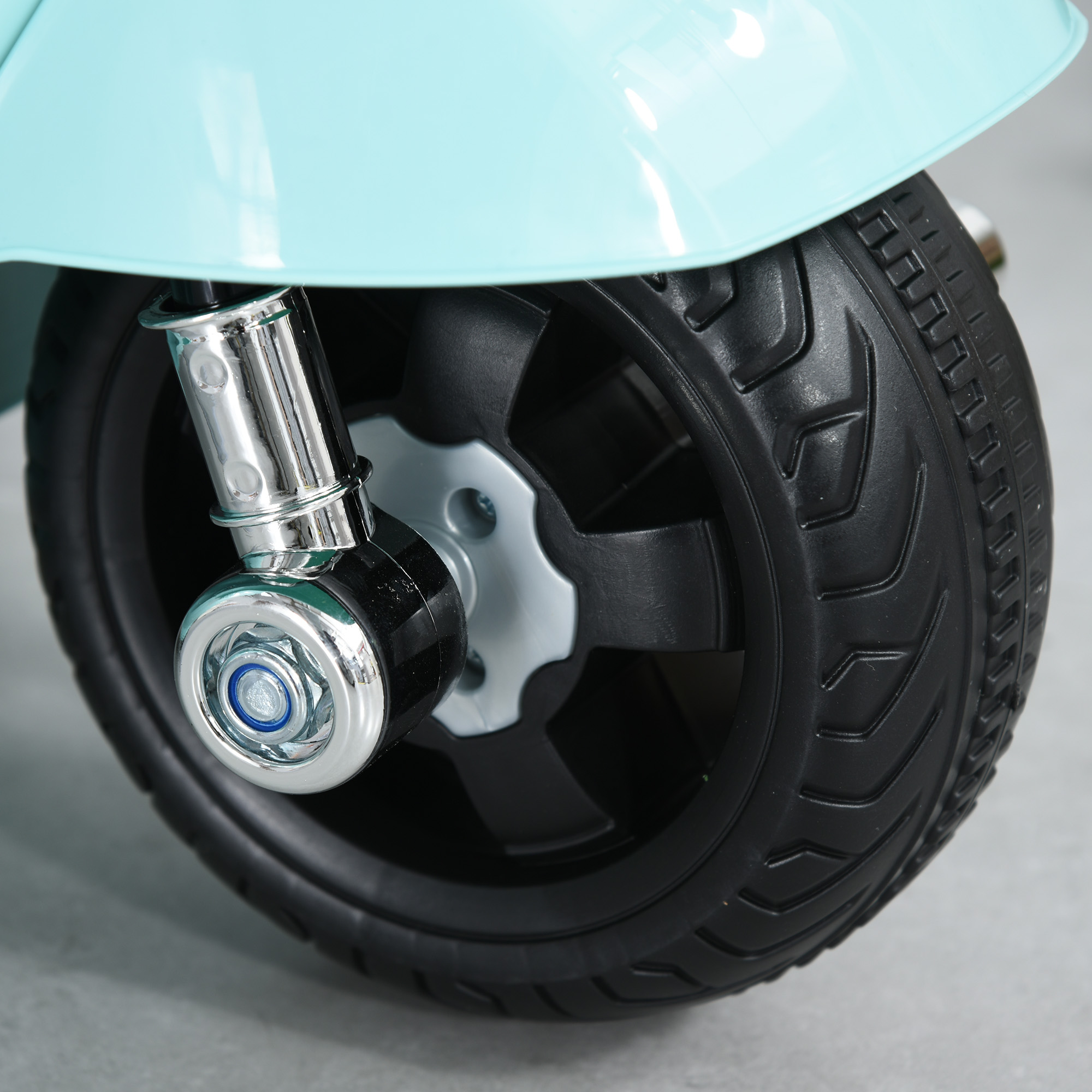 Primo piano di una ruota di scooter blu e di uno pneumatico nero.