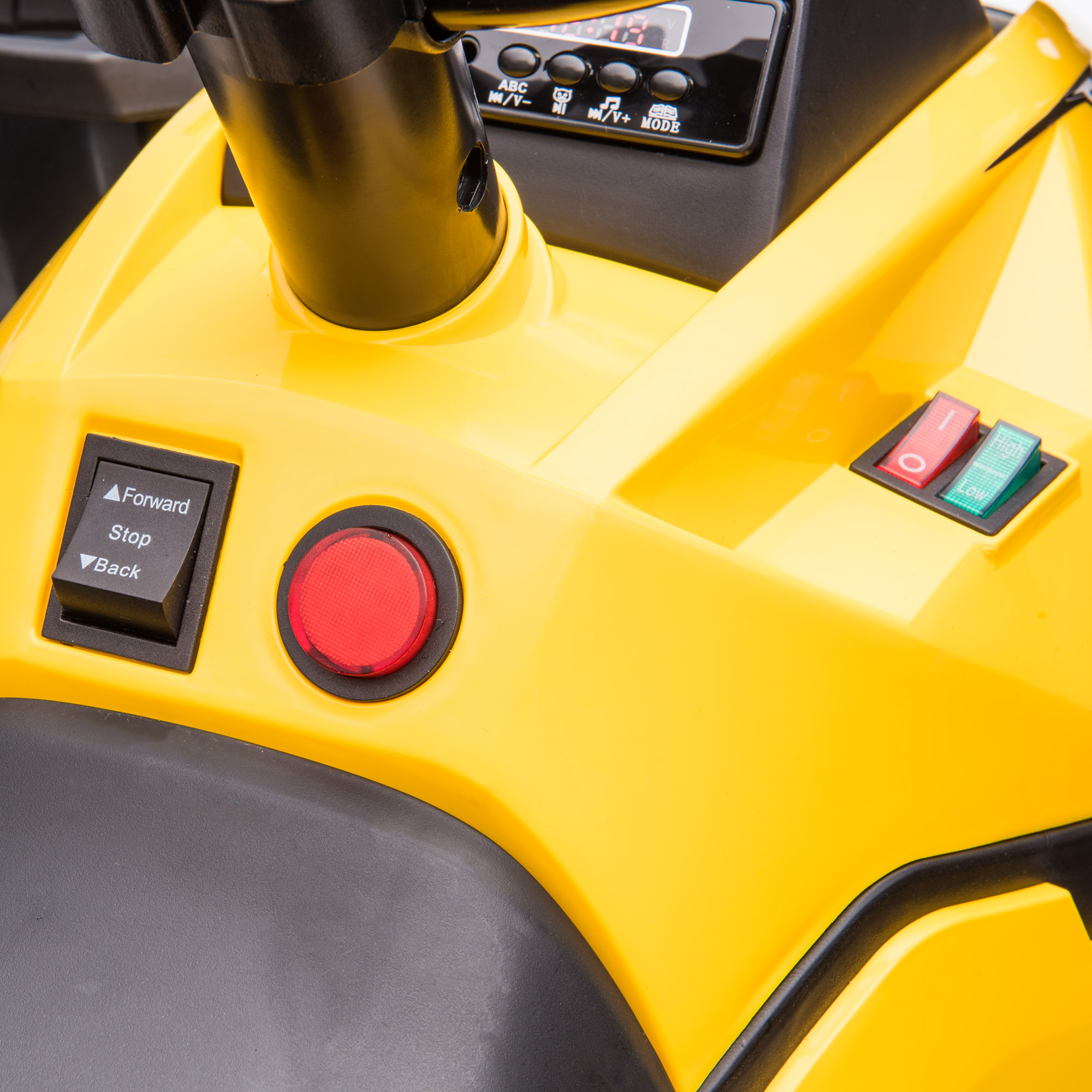 Primo piano del pannello di controllo di un'auto giocattolo gialla, con pulsanti e interruttori.