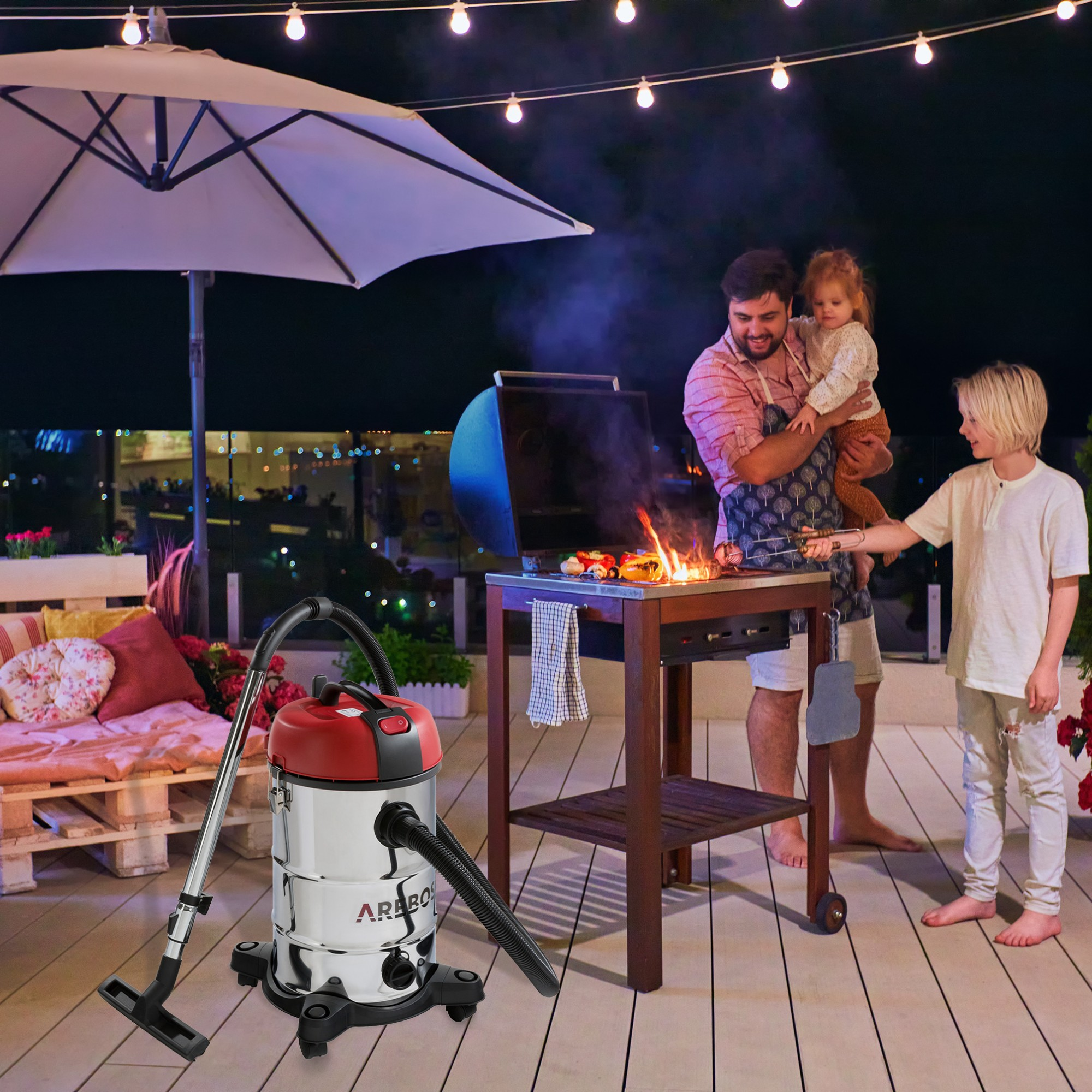 Eine Familie grillt. Ein Mann hält ein Kind, ein Junge hilft. Ein Staubsauger steht daneben.