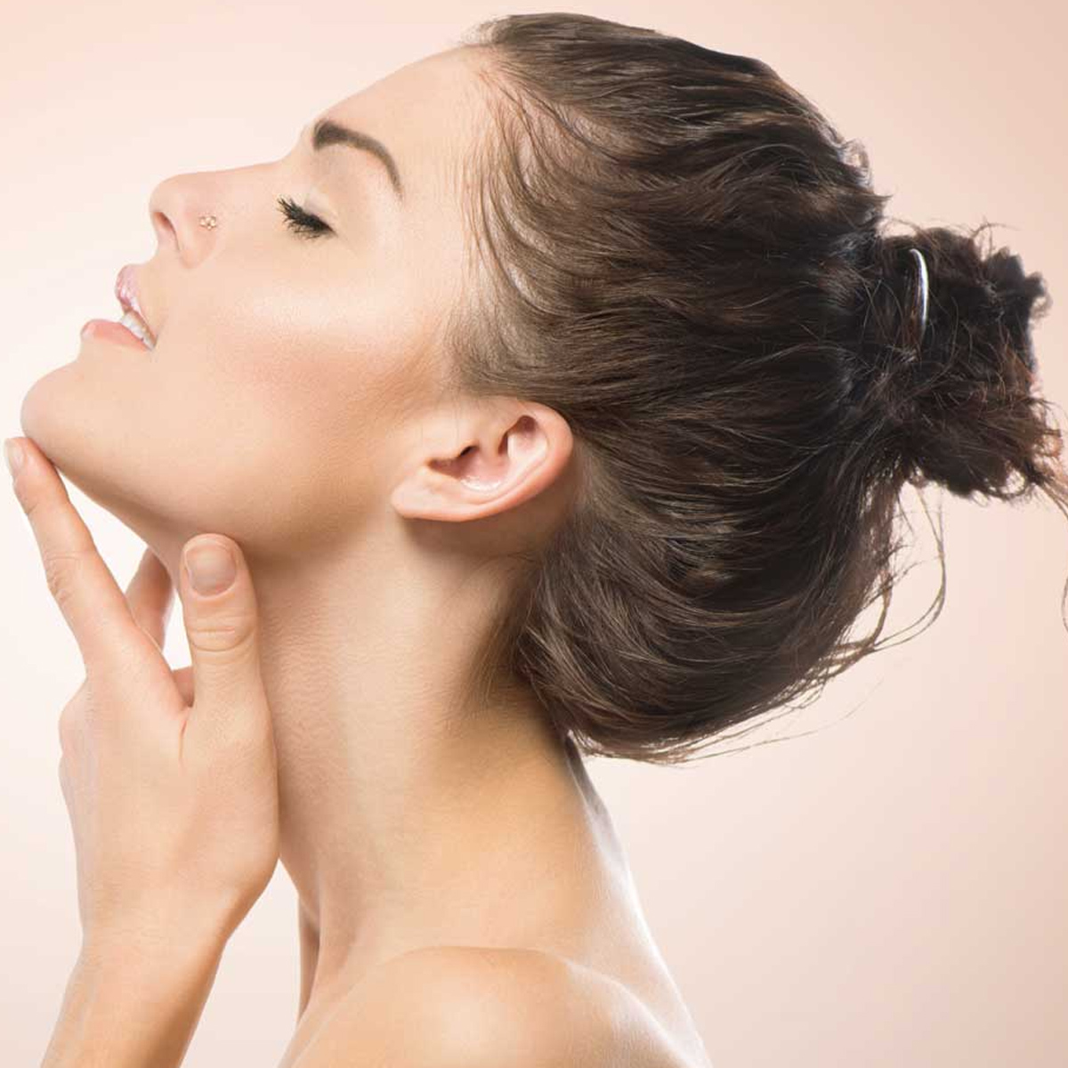 El perfil del rostro de una mujer, con los ojos cerrados y la mano tocando su rostro.