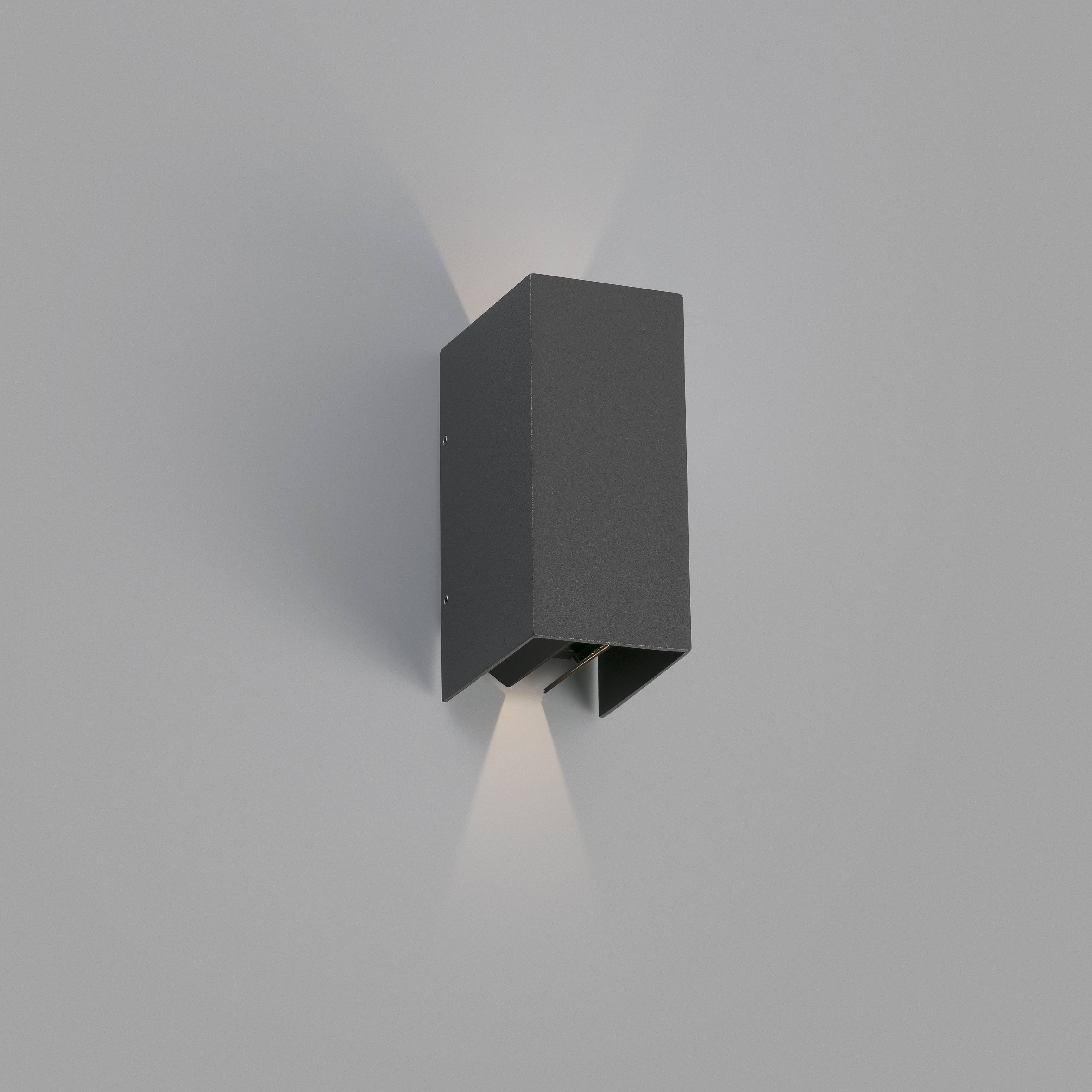 Applique da parete esterna grigia rettangolare con luce verso il basso su muro grigio chiaro.