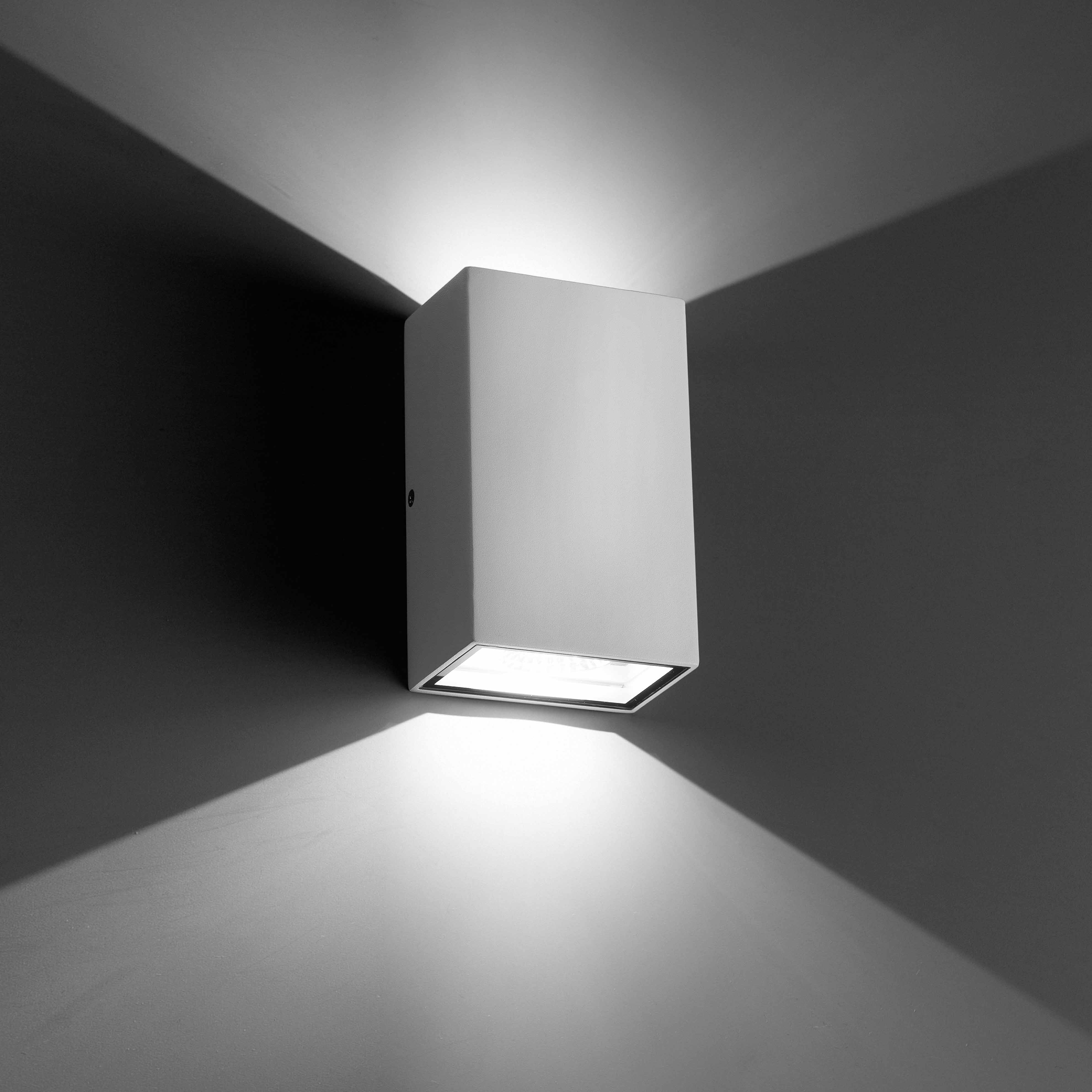 Applique bianca, emette luce verso il basso con ombre.