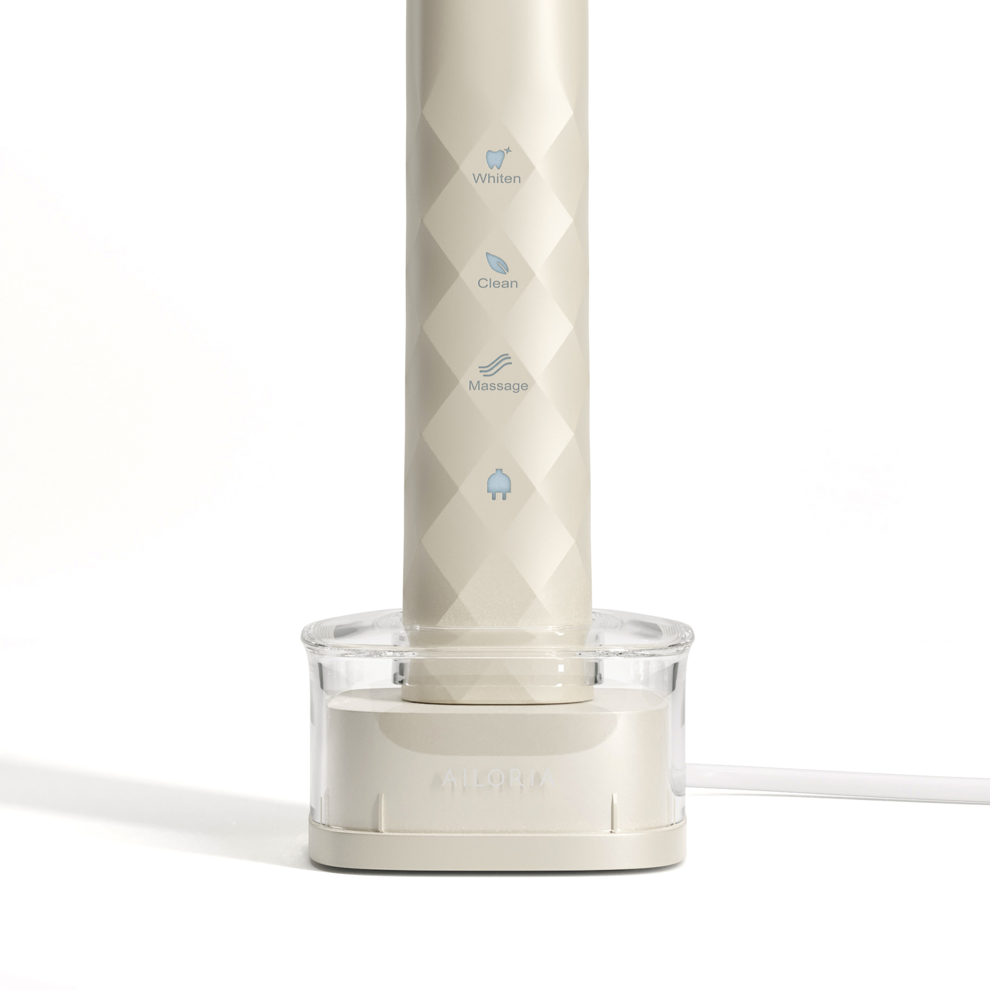 Primer plano de un cepillo de dientes eléctrico beige con base transparente y cable blanco.