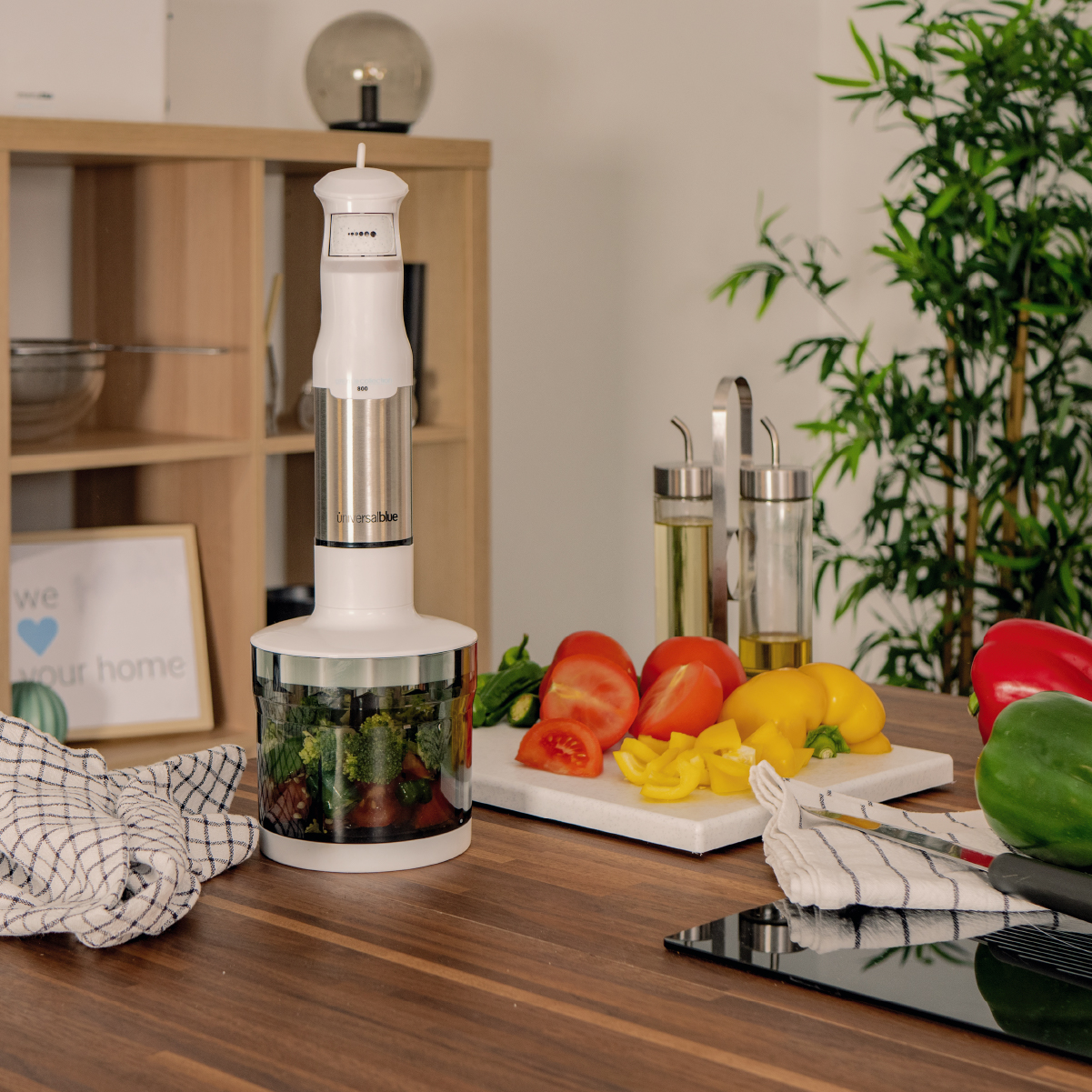 Un frullatore a immersione con verdure e spezie su un tavolo di legno.