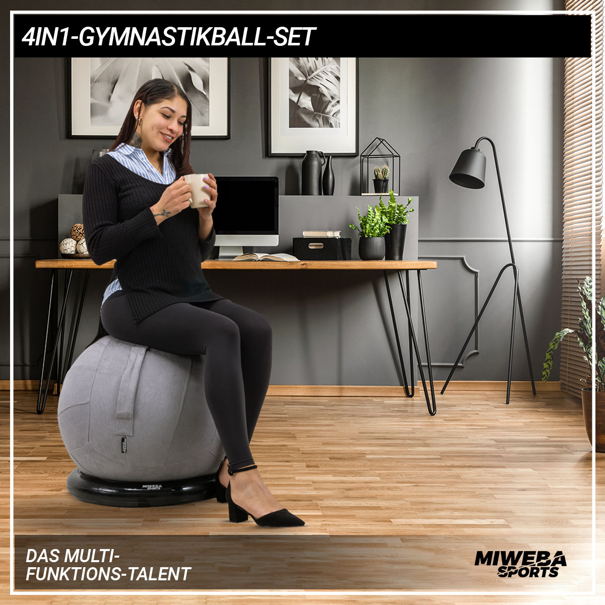 Eine Frau in schwarzer Leggings und Top, die eine Tasse hält, sitzt auf einem grauen Gymnastikball.