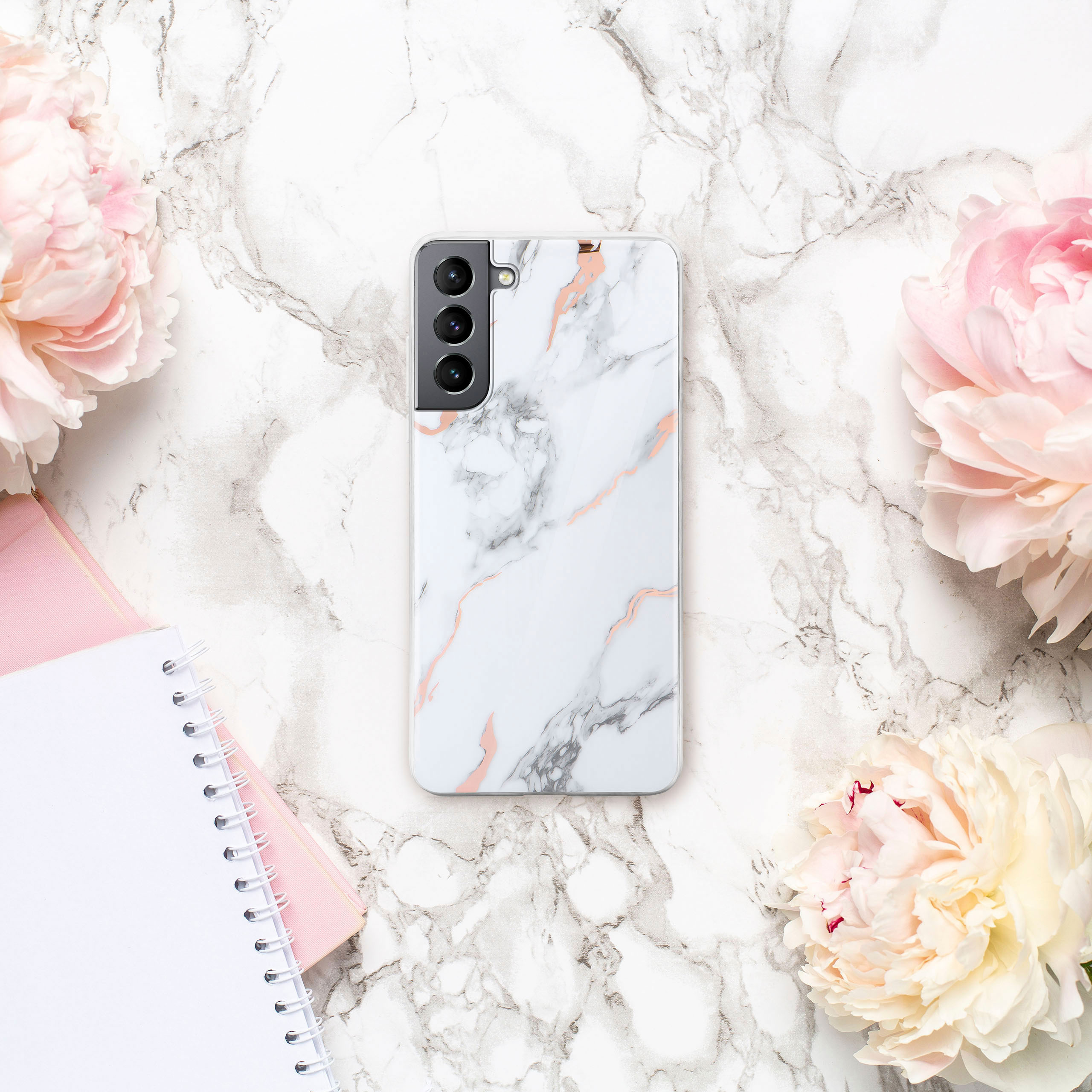 Handyhülle mit Marmordesign, mit rosa Blumen und einem Notizblock.