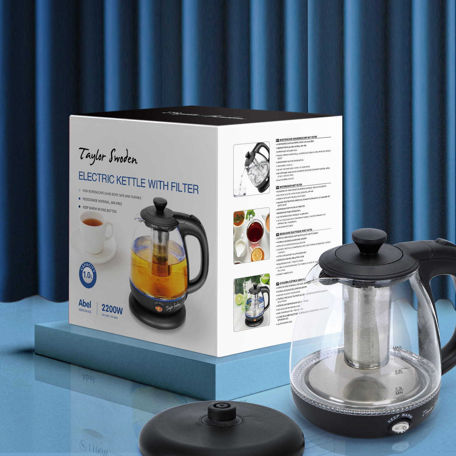 Bollitore elettrico con infusore per tè dentro una scatola. Base nera davanti, sfondo tenda blu.