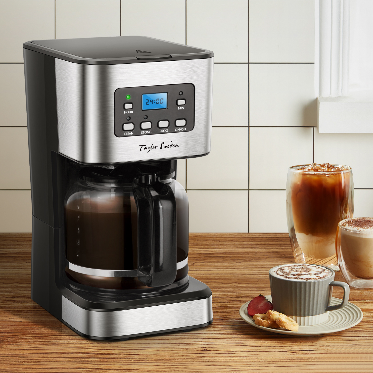 Cafetera con jarra de vidrio y pantalla digital. Dos vasos de café a la derecha.