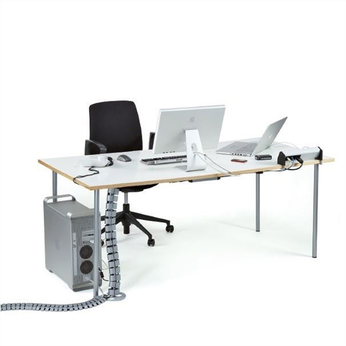 Schreibtisch mit Monitoren, Laptop und Computerturm. Ein schwarzer Stuhl steht dahinter.