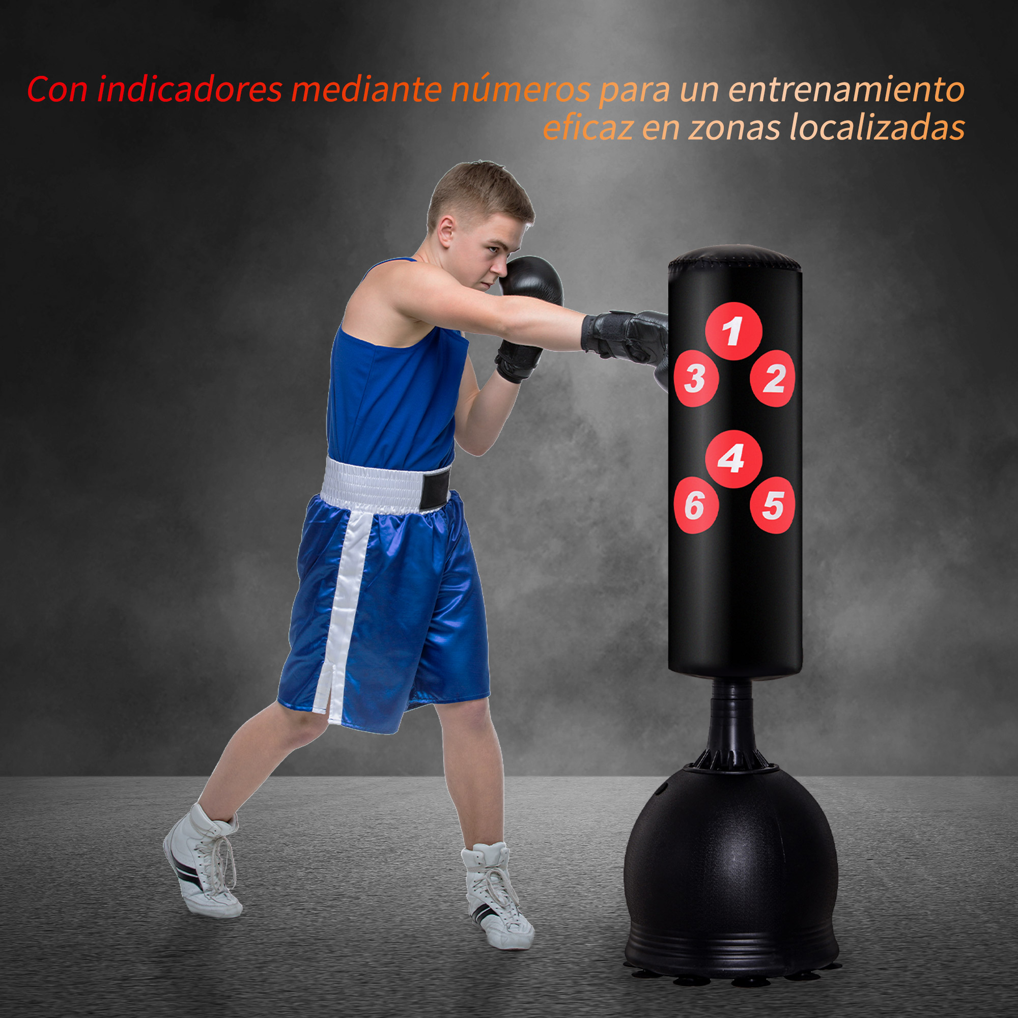 Un joven boxeando. Lleva pantalones cortos azules y guantes negros. Hay un saco de boxeo negro cerca.