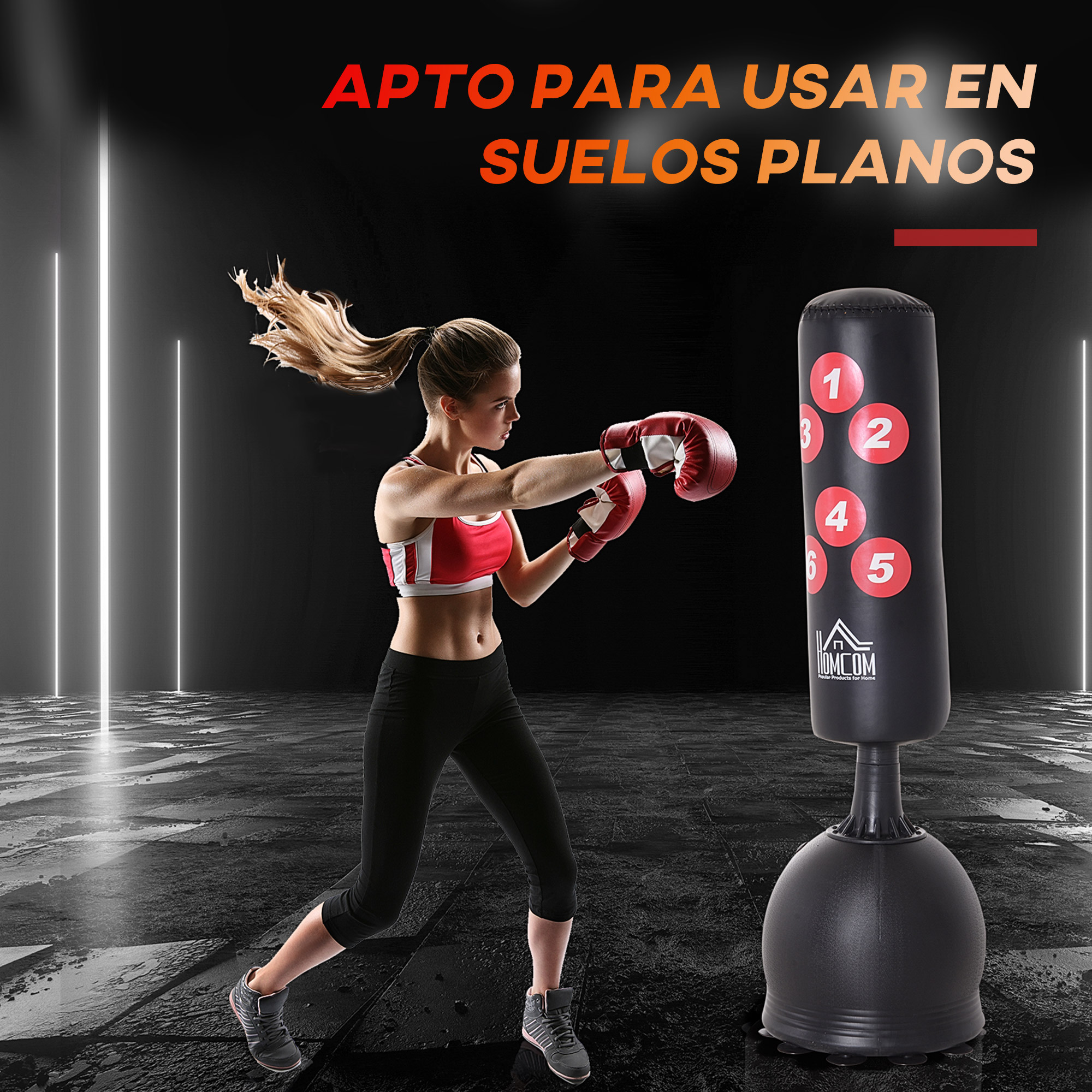 Mujer boxeando un saco de boxeo negro. Guantes rojos. Leggings negros y top rojo. Texto: Apto para suelos planos.