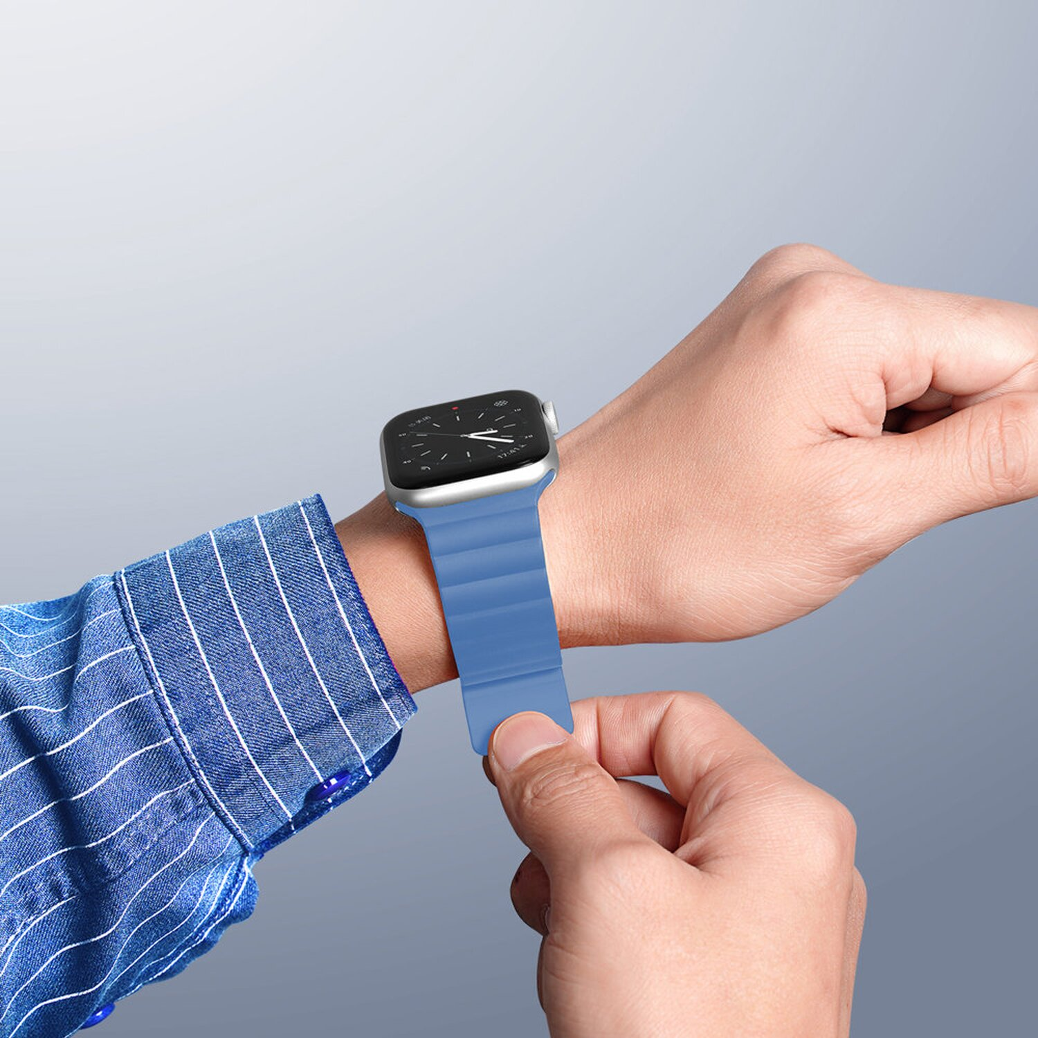 Person trägt blaue Uhr am Handgelenk und passt das Armband an. Nahaufnahme.