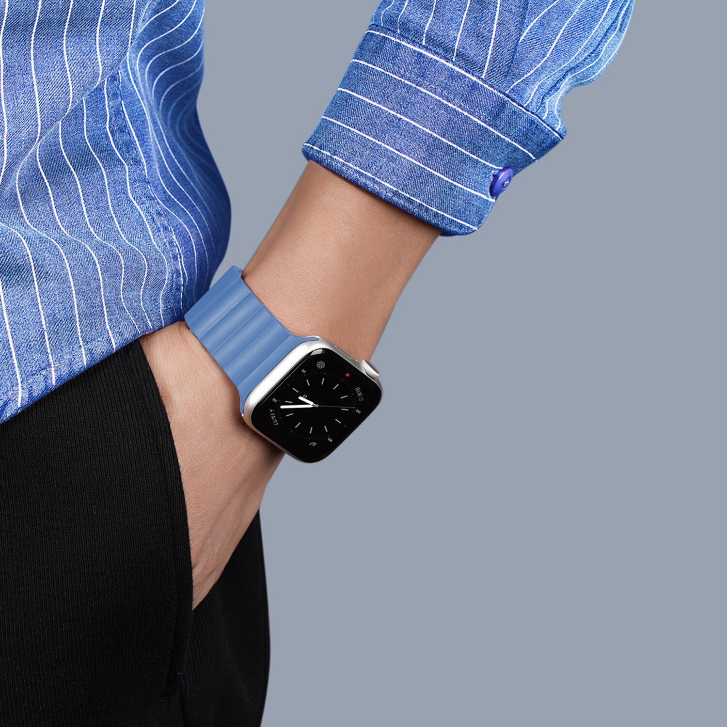 Handgelenk mit blauem Armband und silberner Uhr. Die Uhr zeigt eine digitale Anzeige.