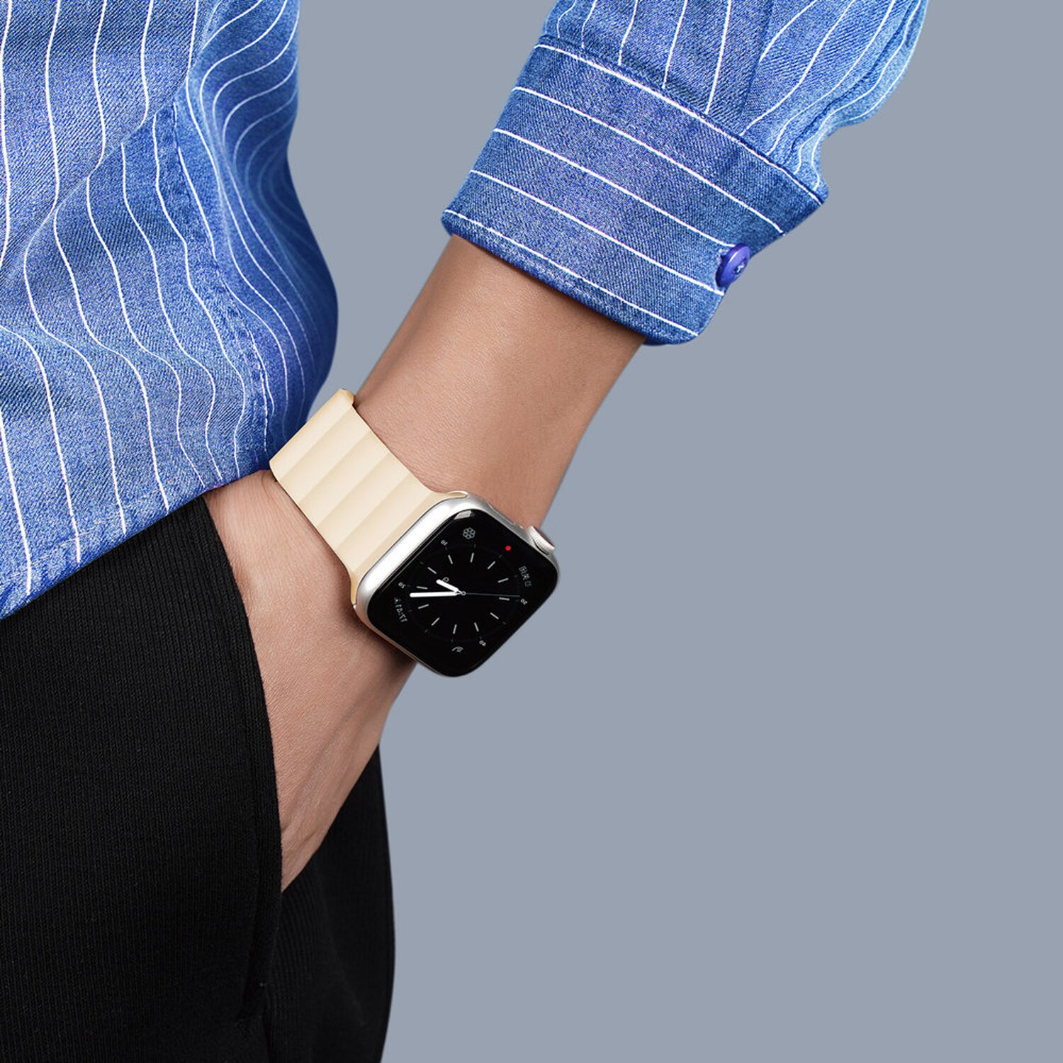 Handgelenk mit Smartwatch. Die Uhr hat ein silbernes Gehäuse und ein beiges Armband.