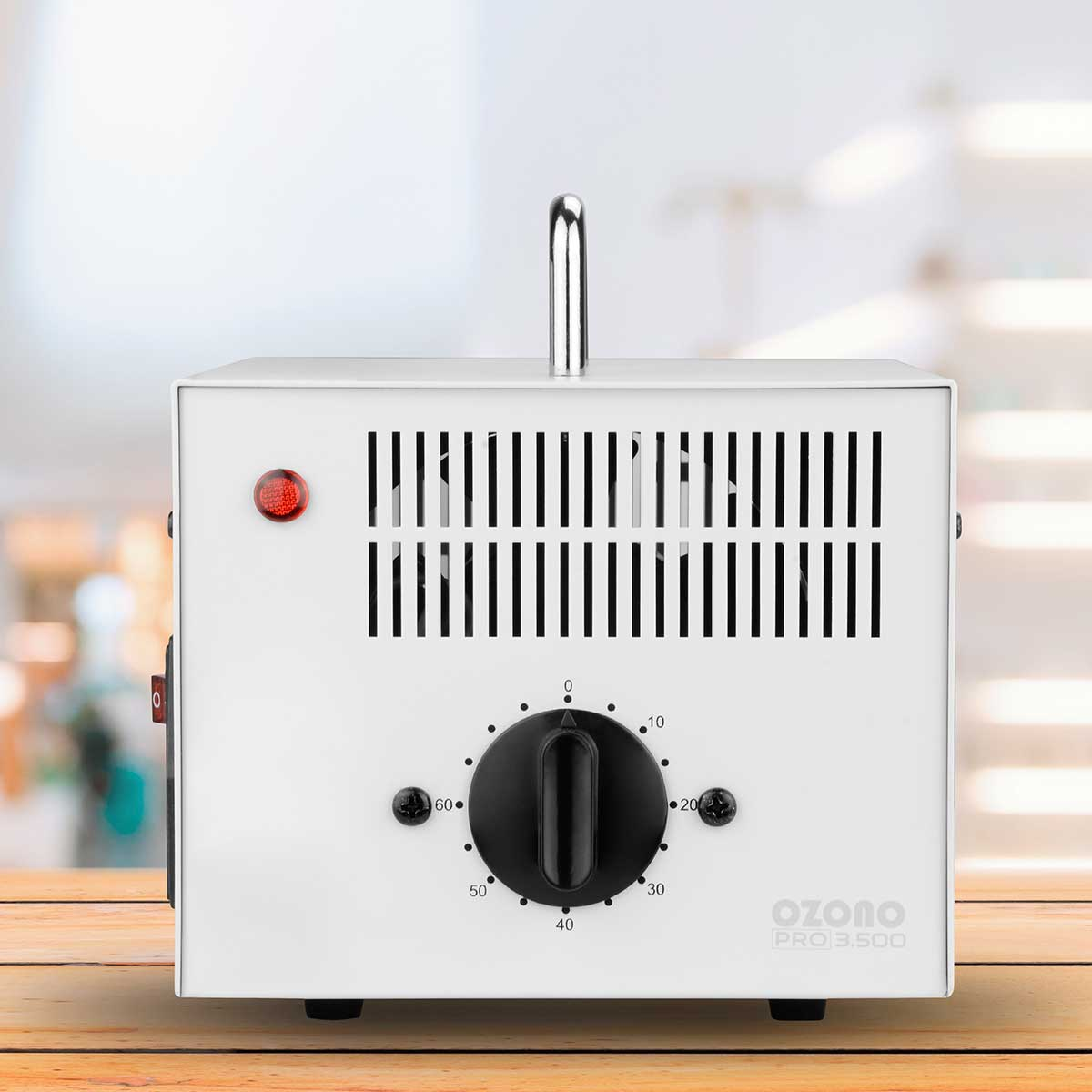 Purificador de aire blanco Ozone Pro 3.500. Tiene una manija, rejillas de ventilación, un dial de control y una luz roja.
