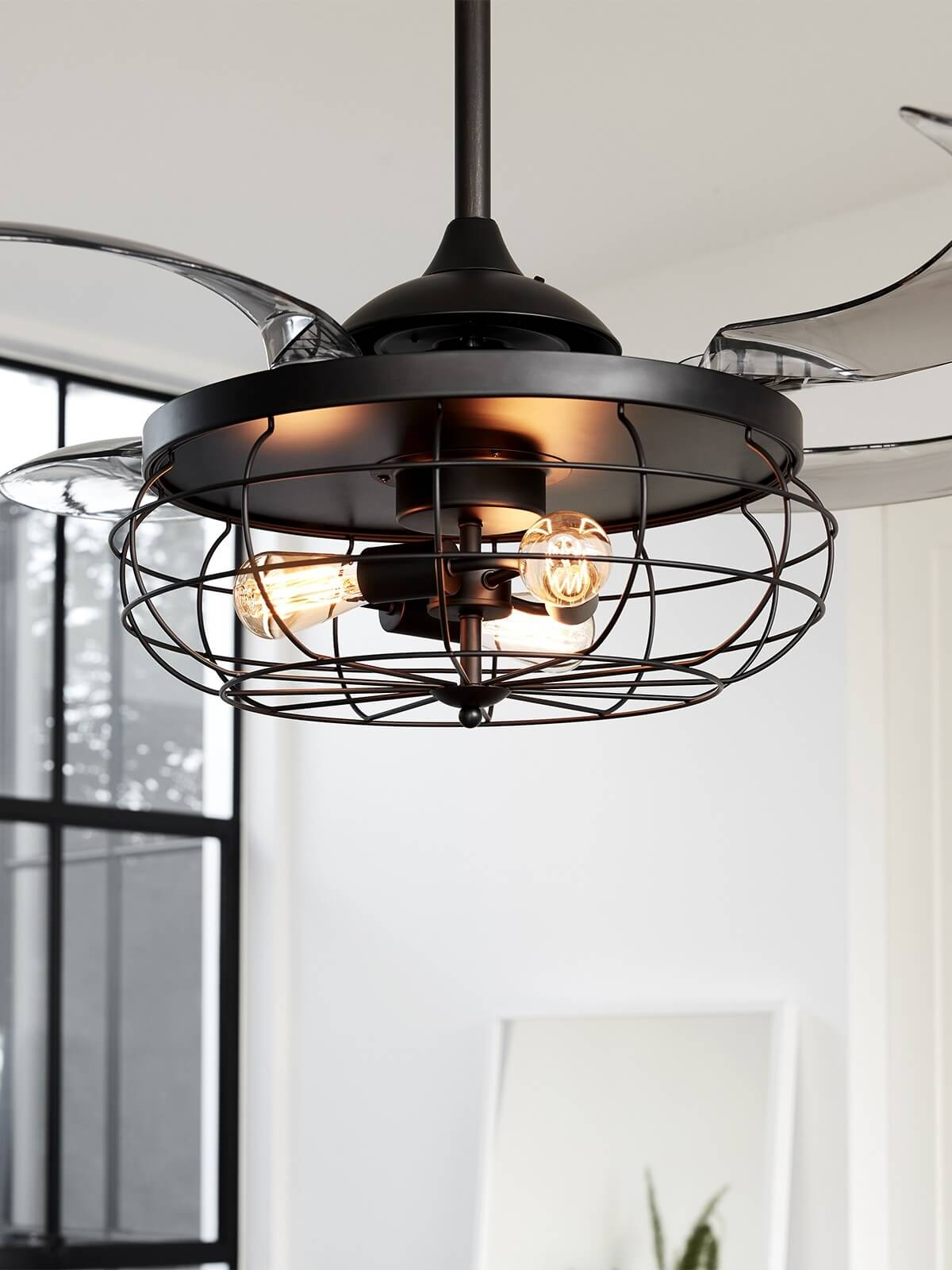 Ein schwarzer Deckenventilator mit drei Lichtern. Die Lichter sind von einem Metallkäfig bedeckt.