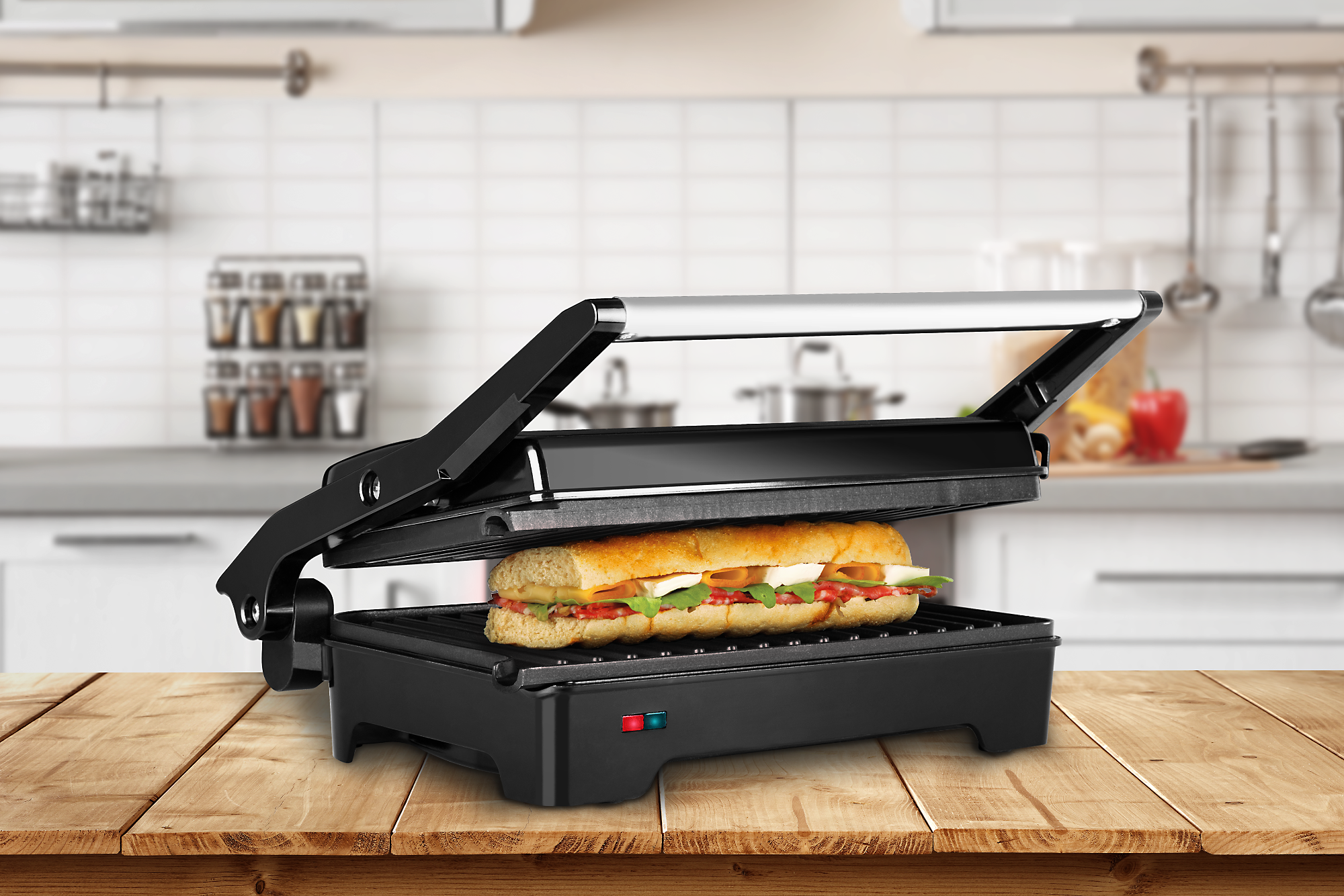 Schwarzer Sandwichmaker mit gefülltem Sandwich. Im Hintergrund eine Küchenszene.