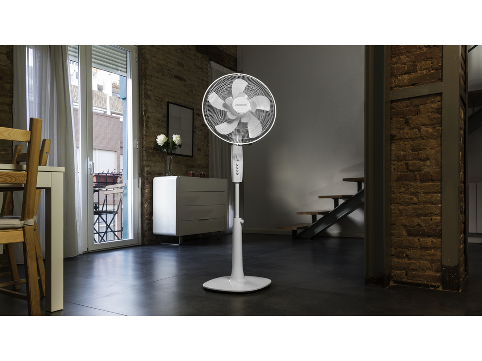 Biały wentylator stojący w pokoju. Wentylator jest wyśrodkowany.