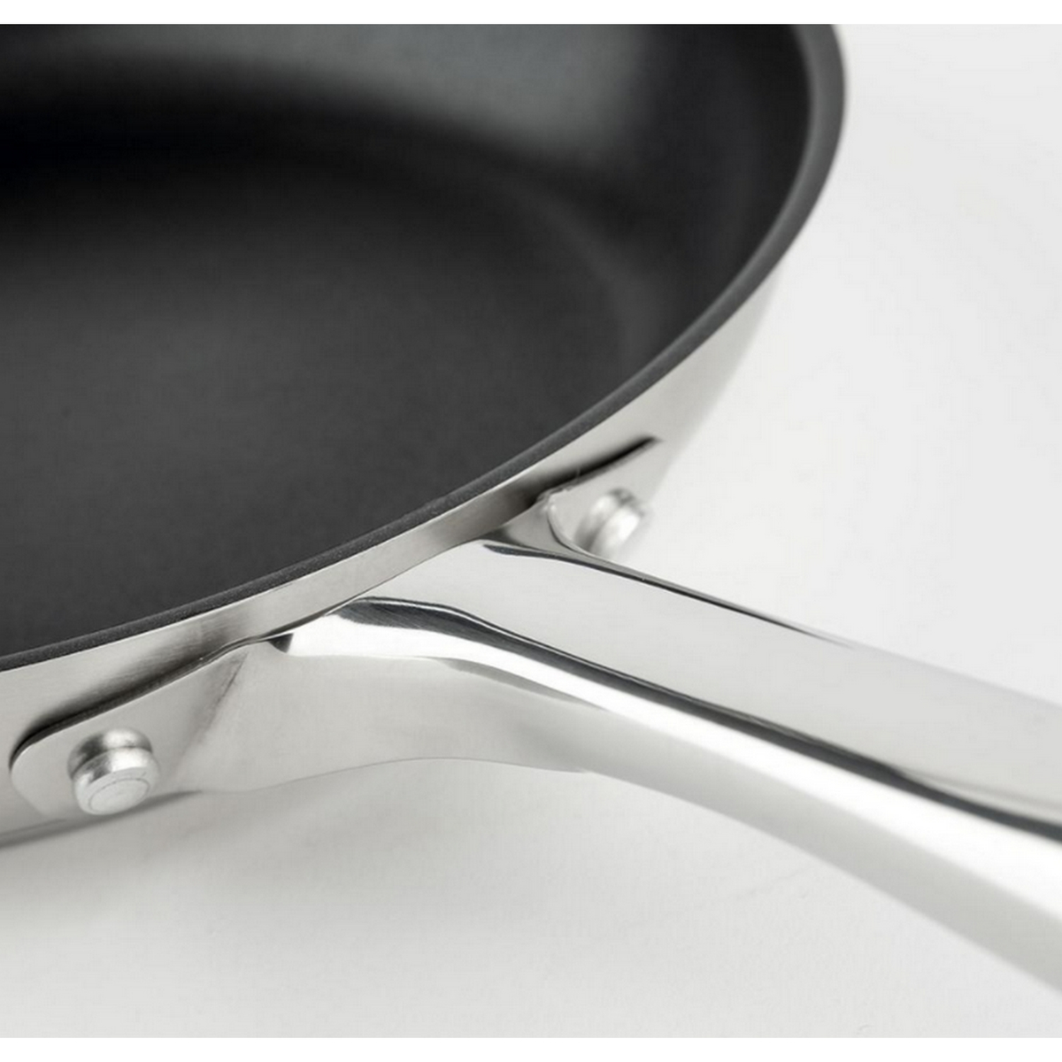 Patelnia ze stali nierdzewnej. Czarne wnętrze. Uchwyt mocowany nitami.