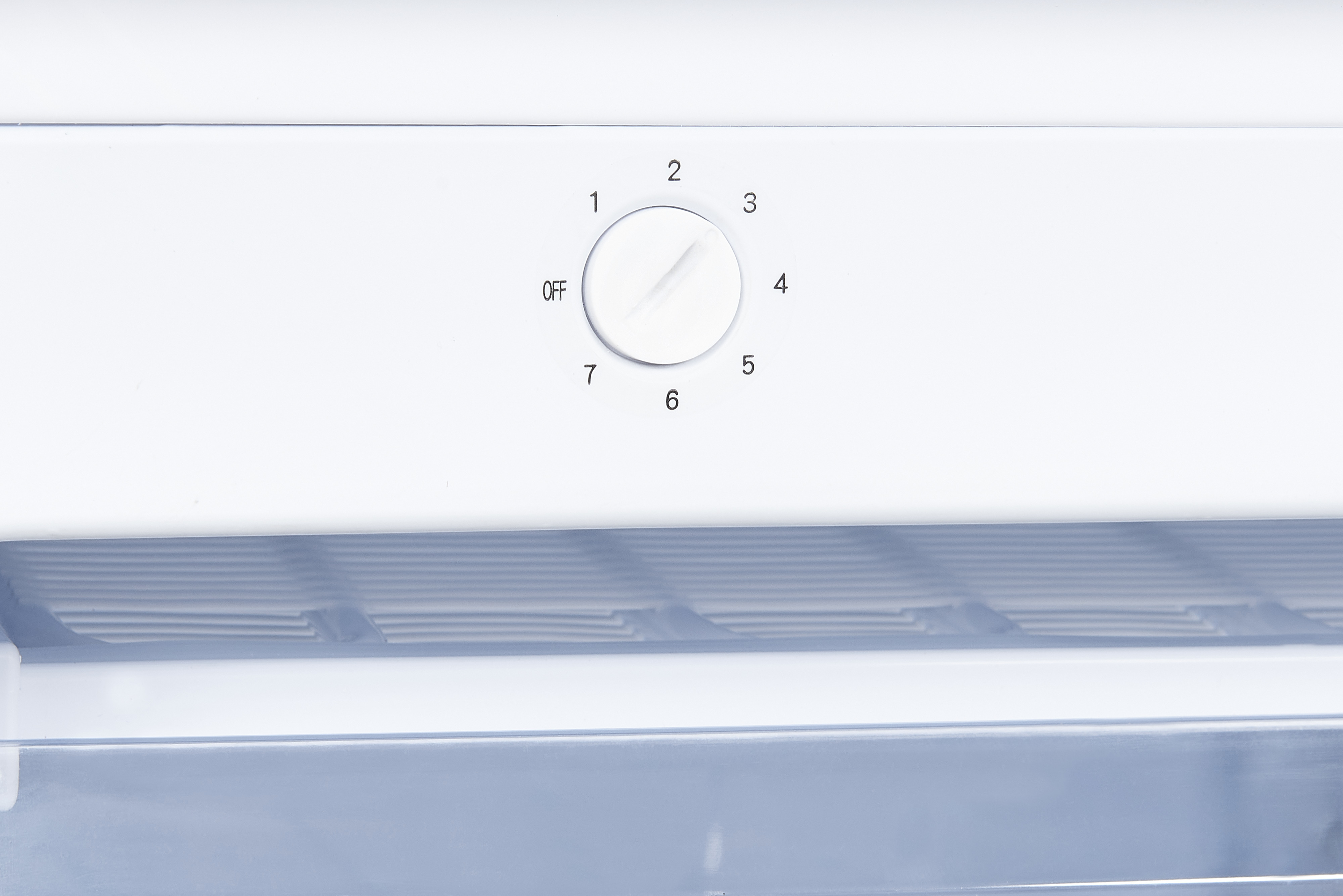 Bouton de commande de réfrigérateur blanc avec numéros et réglage 'arrêt', sur fond blanc.