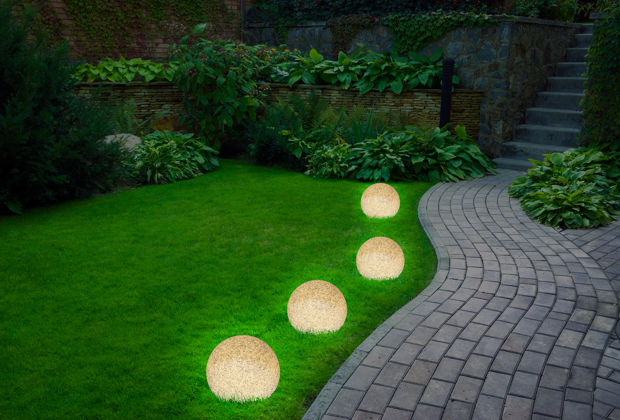 Garten mit grünem Gras und Steinweg, beleuchtet von leuchtenden Kugellichtern.