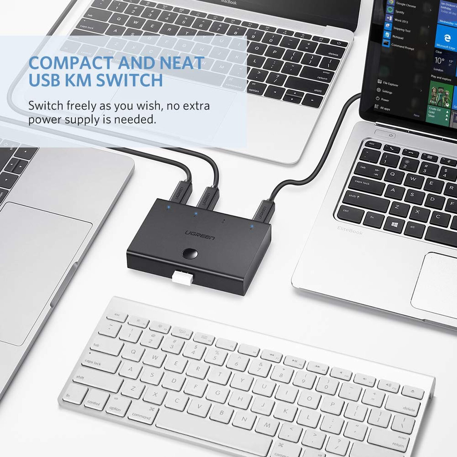 USB-KM-Switch mit zwei Laptops und einer Tastatur auf weißer Oberfläche.
