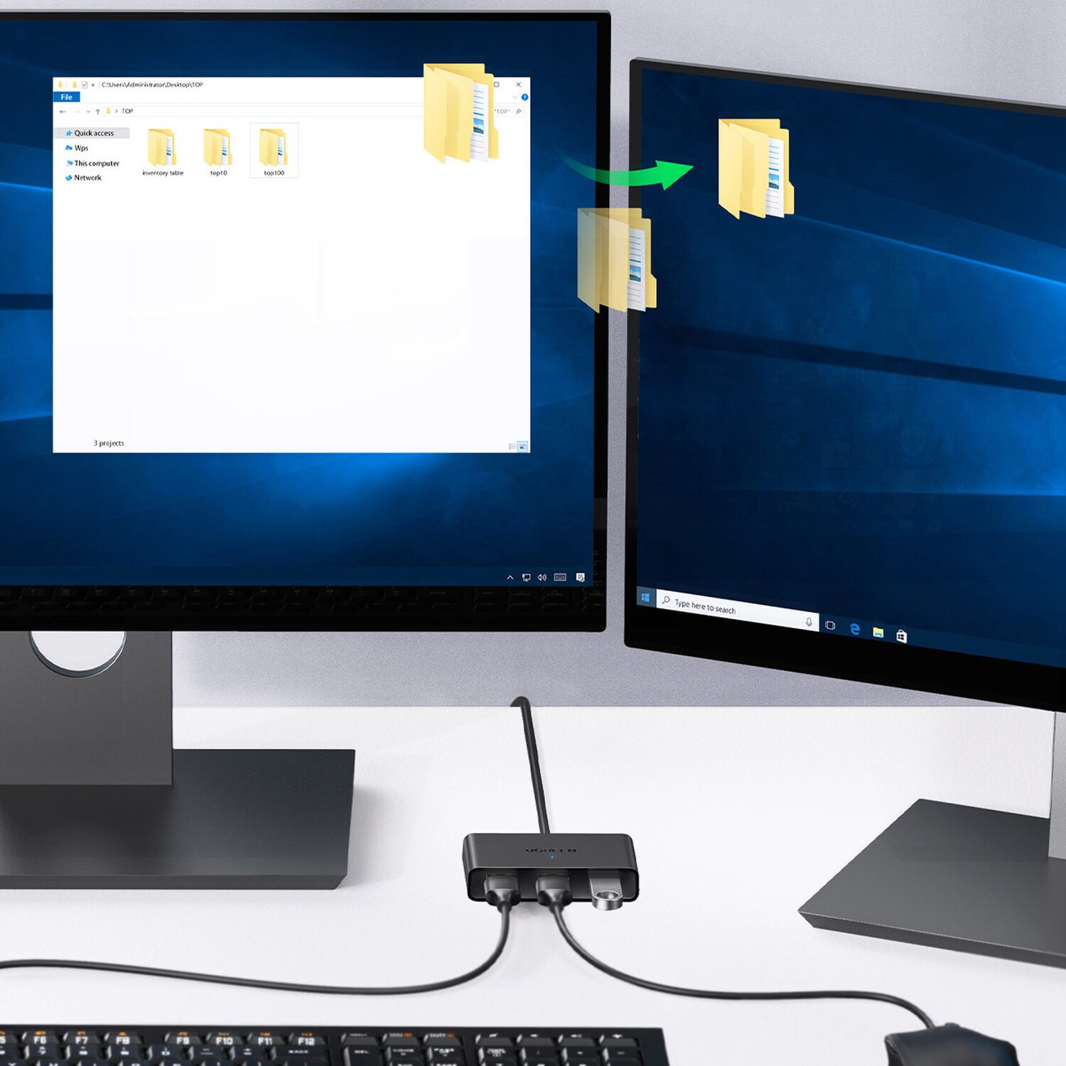 Due monitor che visualizzano file. Un hub li collega a tastiera e mouse.