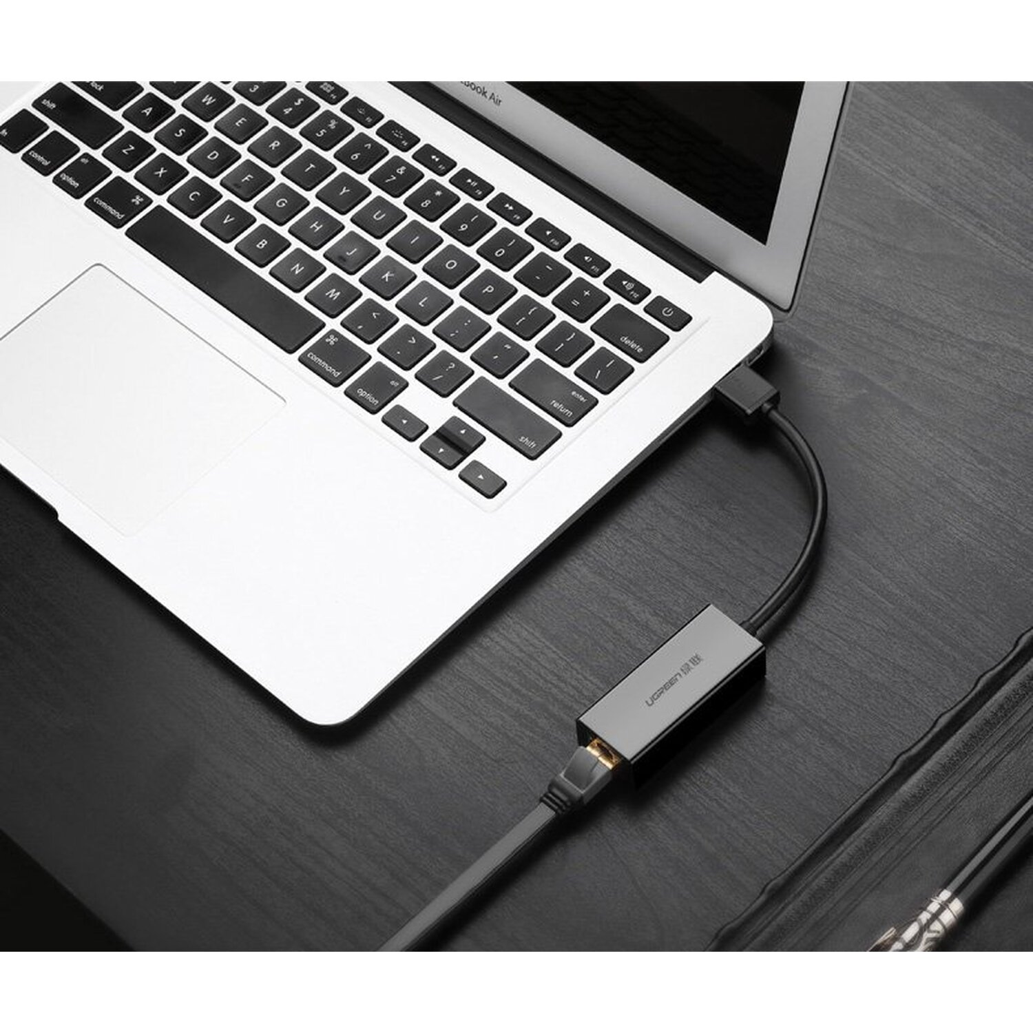 Bağlı bir USB-C adaptörüne sahip dizüstü bilgisayar. Adaptör, siyah bir kabloya bağlı.