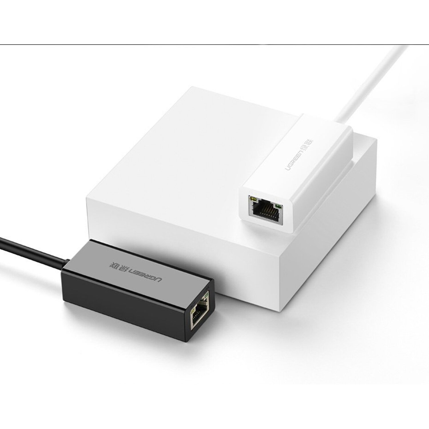 Beyaz ve siyah UGREEN Ethernet adaptörü beyaz bir bloğa bağlı.