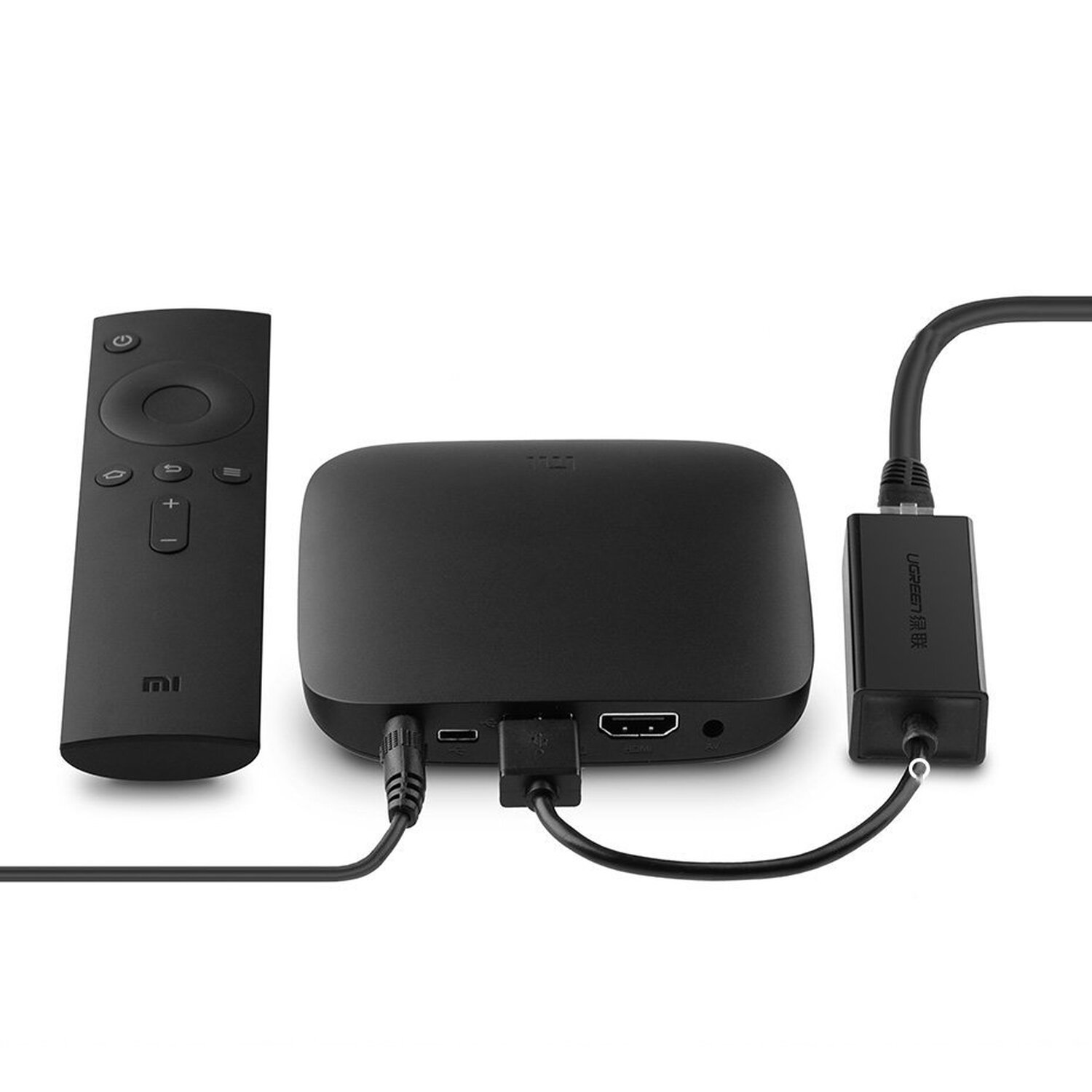 Siyah medya oynatıcı ve uzaktan kumanda, HDMI kablosu ve adaptör ile.
