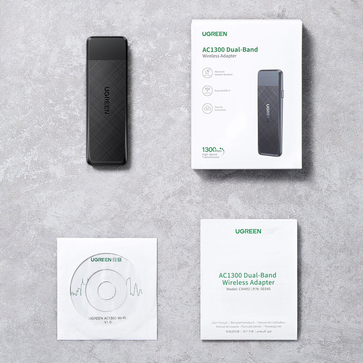 Drahtloser Adapter, Box und Zubehör auf weißer Oberfläche.